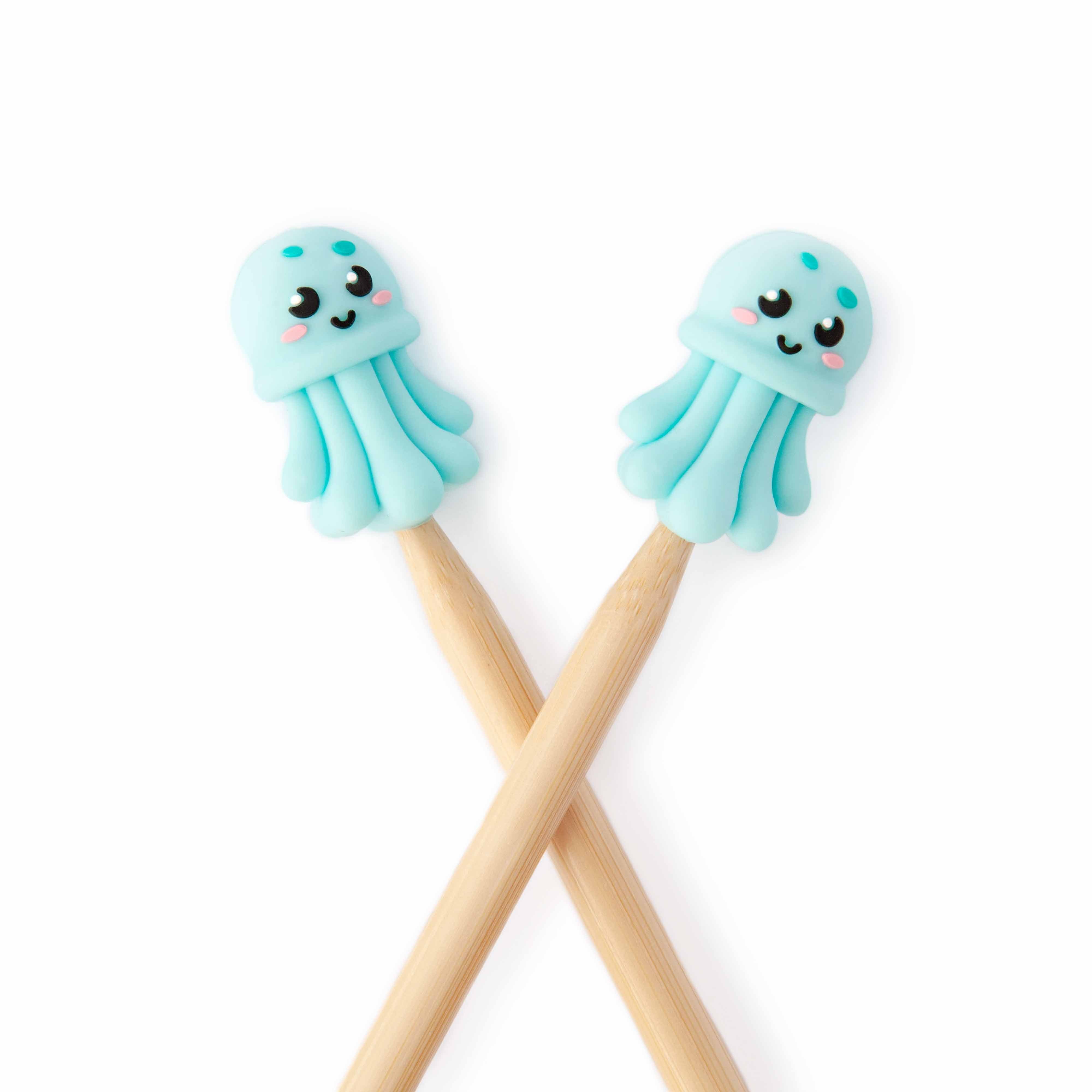 Jellyfish Knitting Needle Point Protectors on crossed wooden knitting needles from the 2026 Mermaid Summer Box