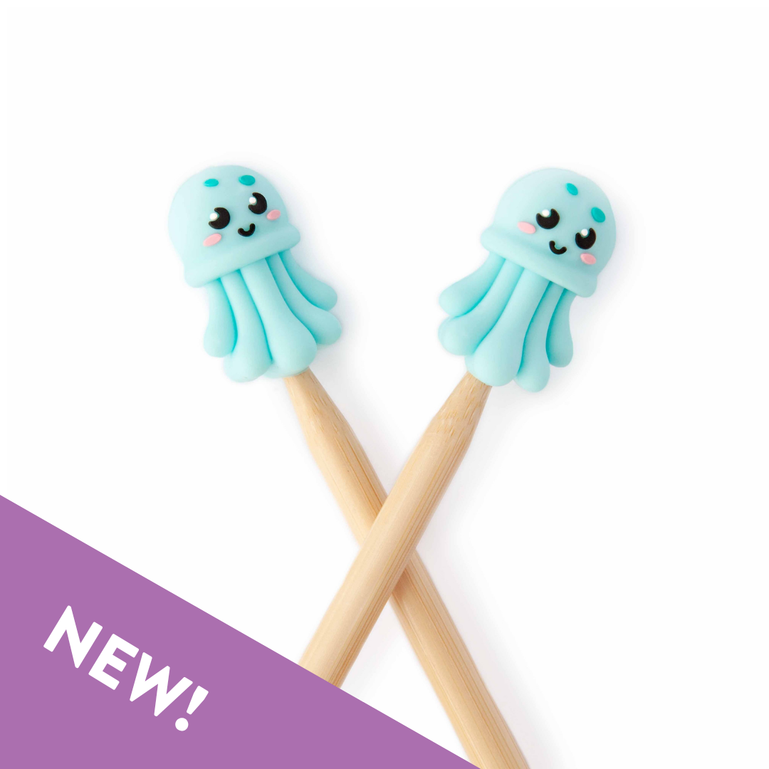 Two blue jellyfish-shaped point protectors on wooden knitting needles on a white background, labeled 'NEW!'.