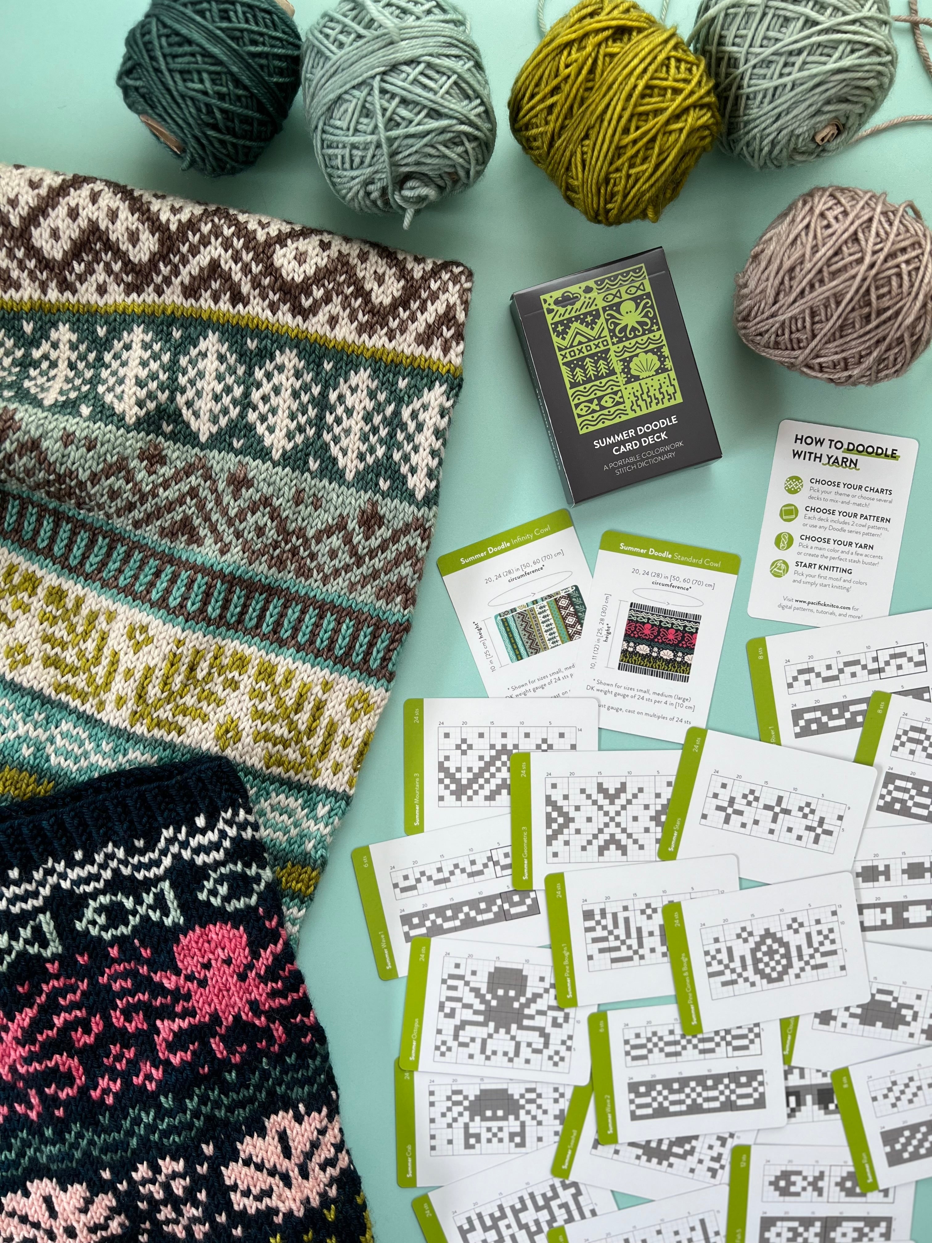 Summer Doodle chart cards spread beside a sea-themed colorwork knit and yarn balls