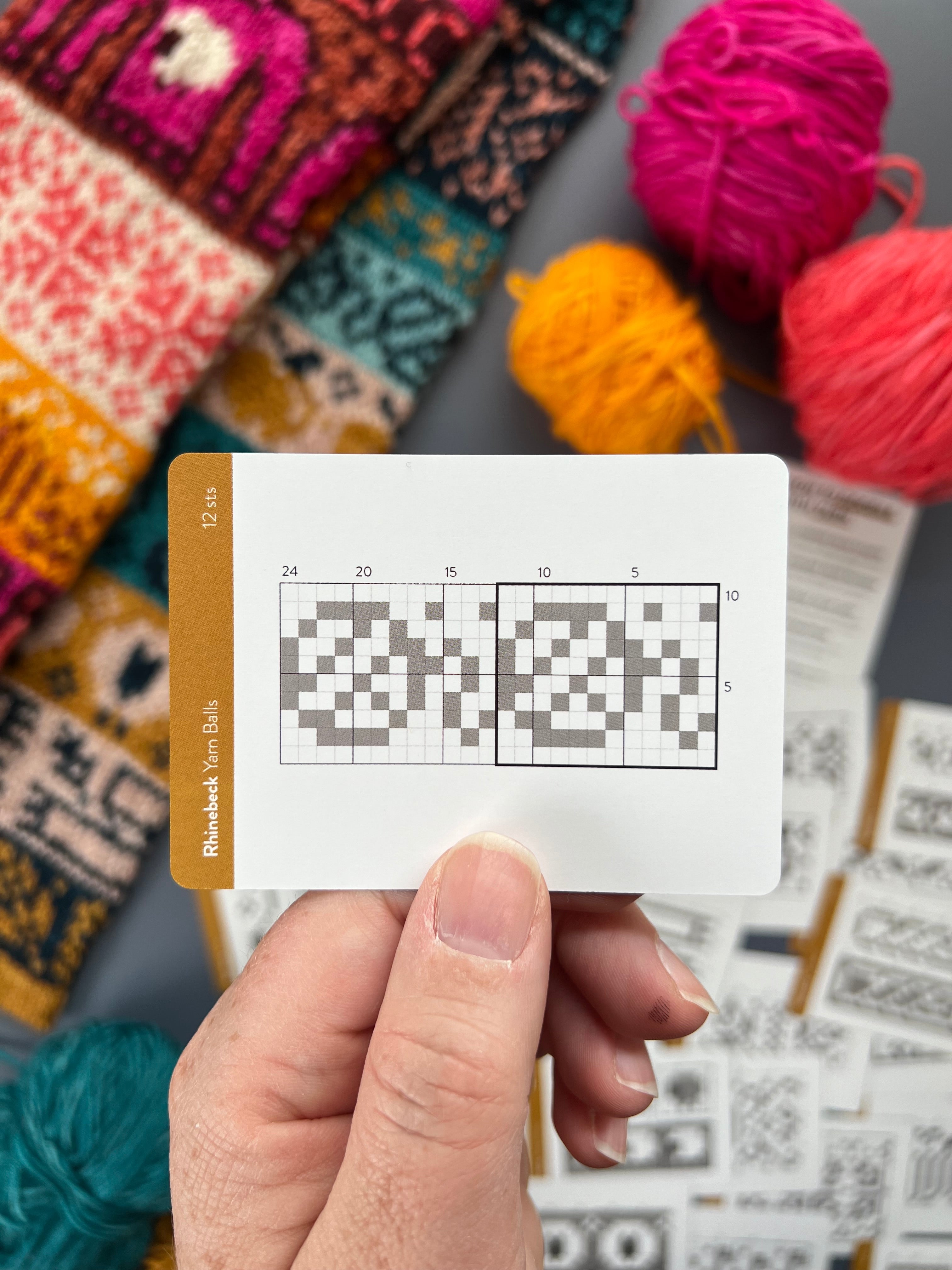Hand holding a Rhinebeck Doodle yarn skein colorwork chart card
