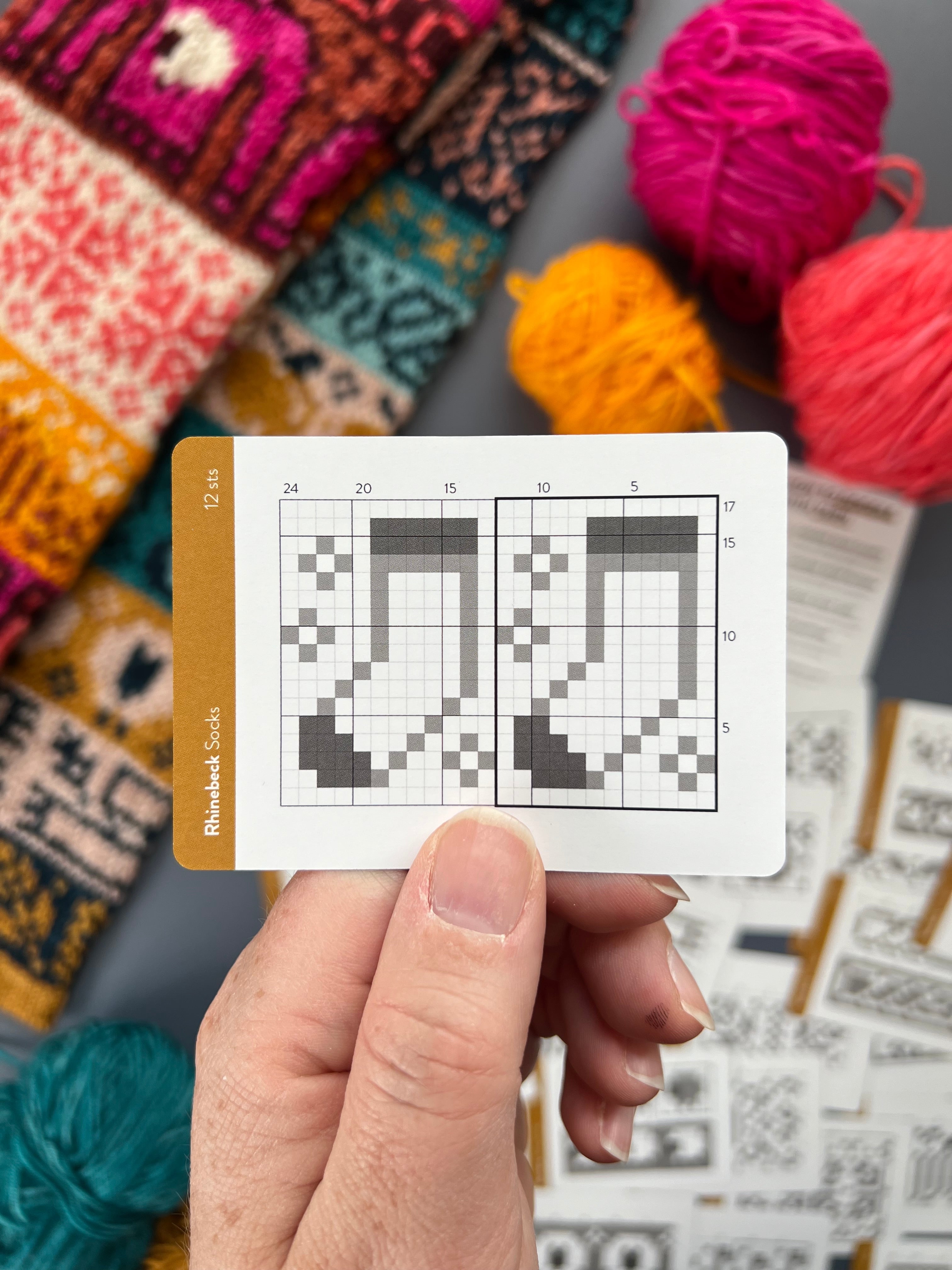 Hand holding a Rhinebeck Doodle socks colorwork chart card
