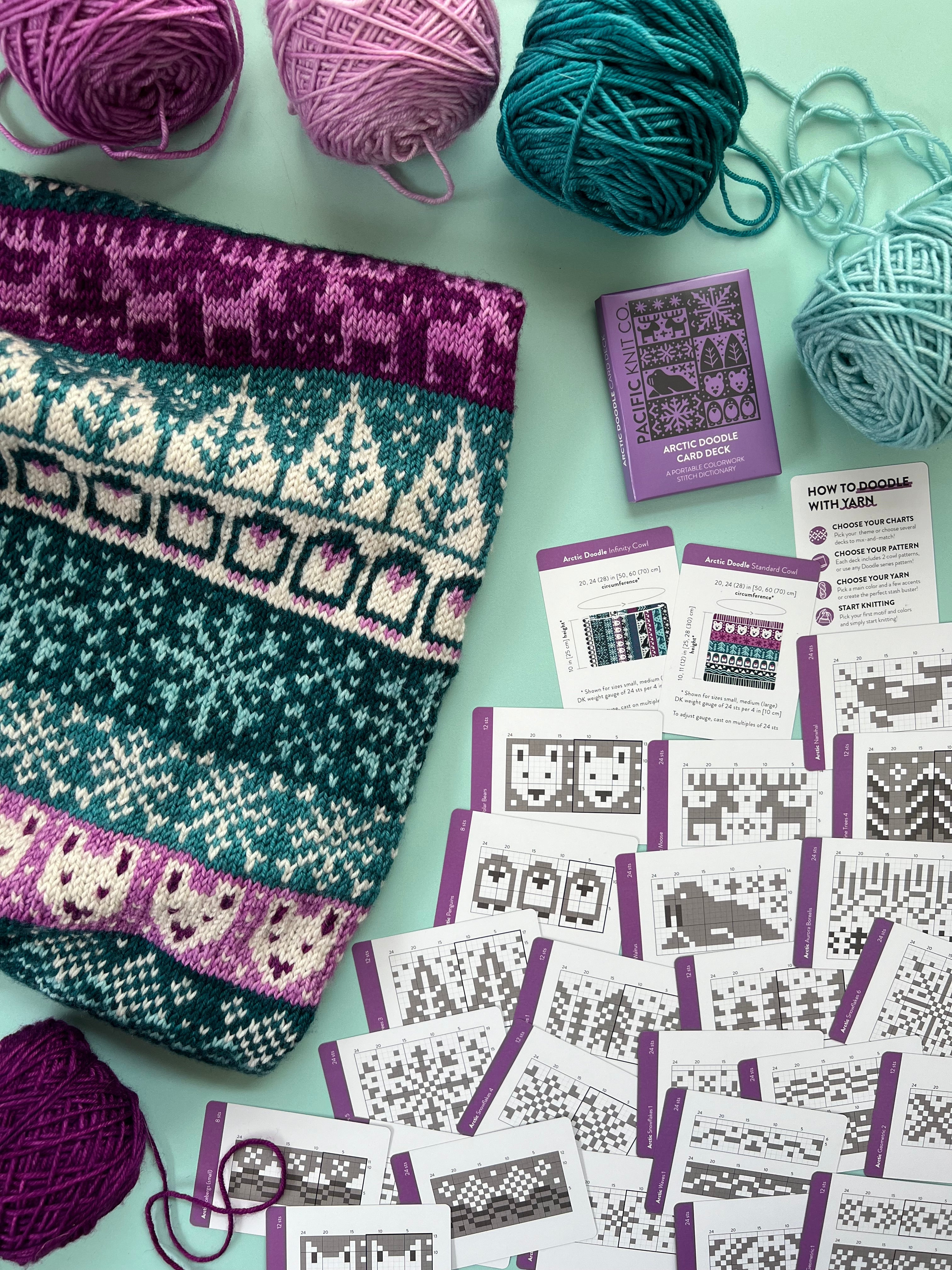 Arctic Doodle chart cards beside a teal and purple polar colorwork knit