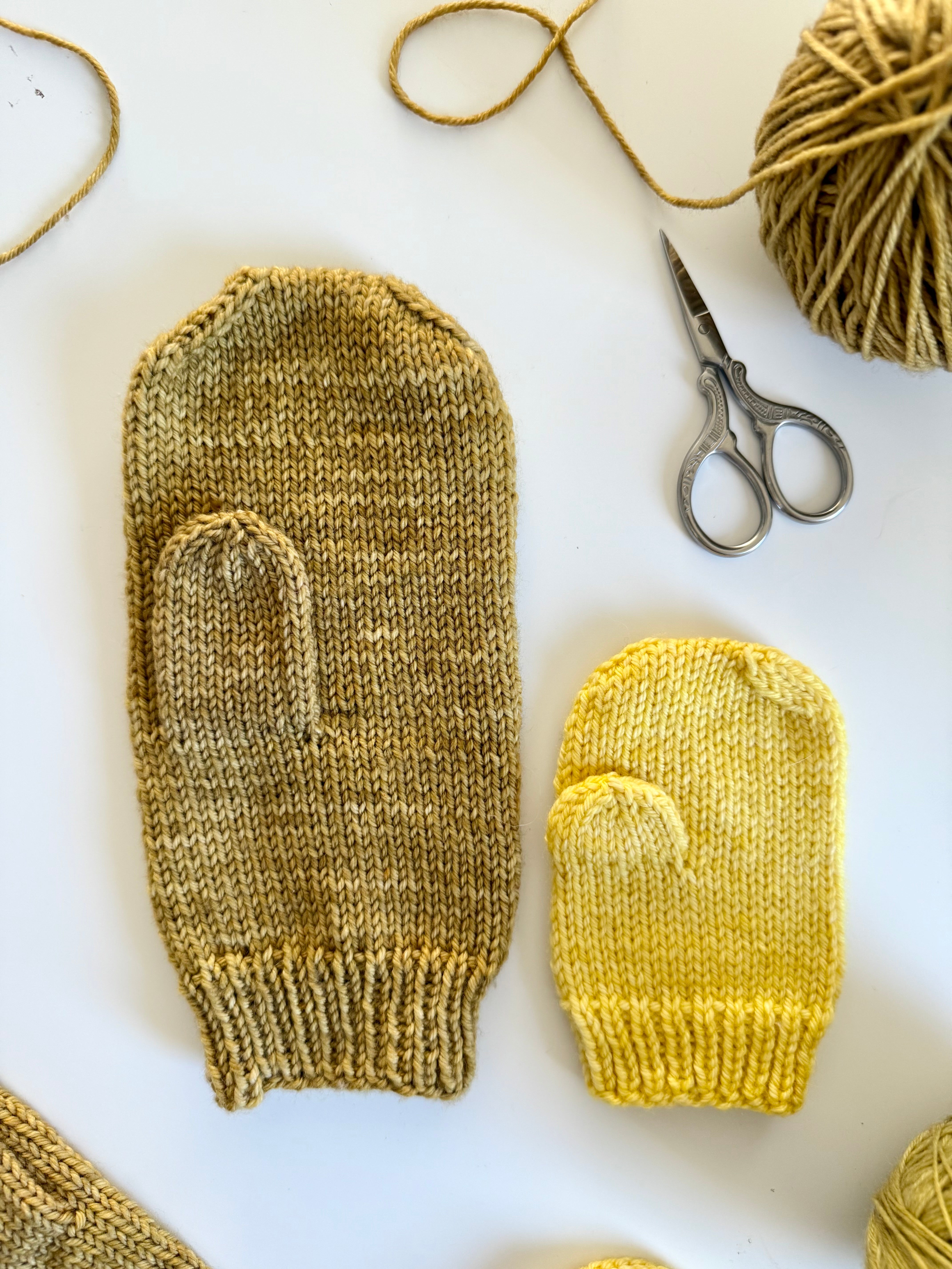 Close-up of olive and yellow Base Doodle Mittens showing the thumbs