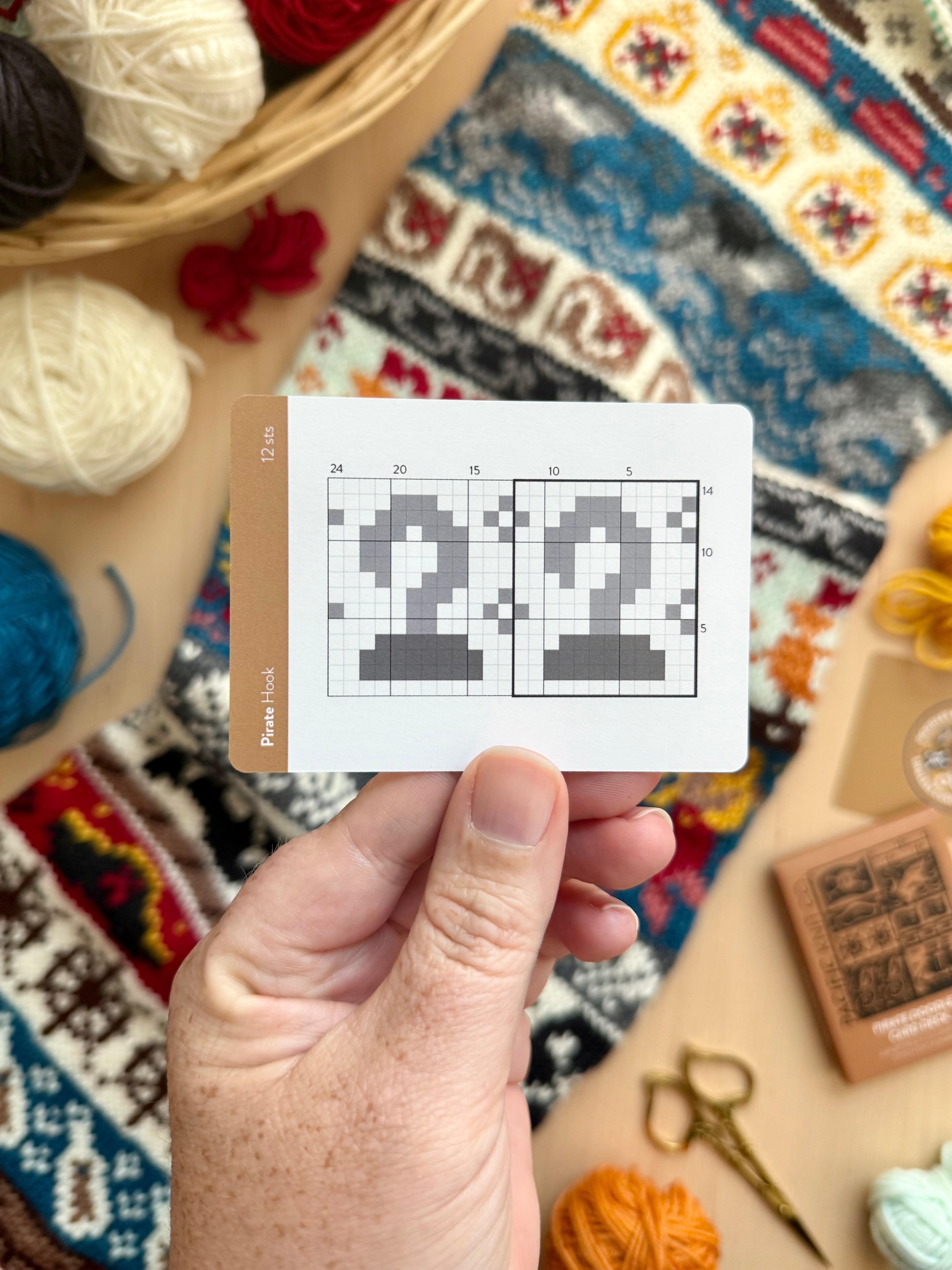 Hand holding a Pirate Doodle anchor colorwork chart card