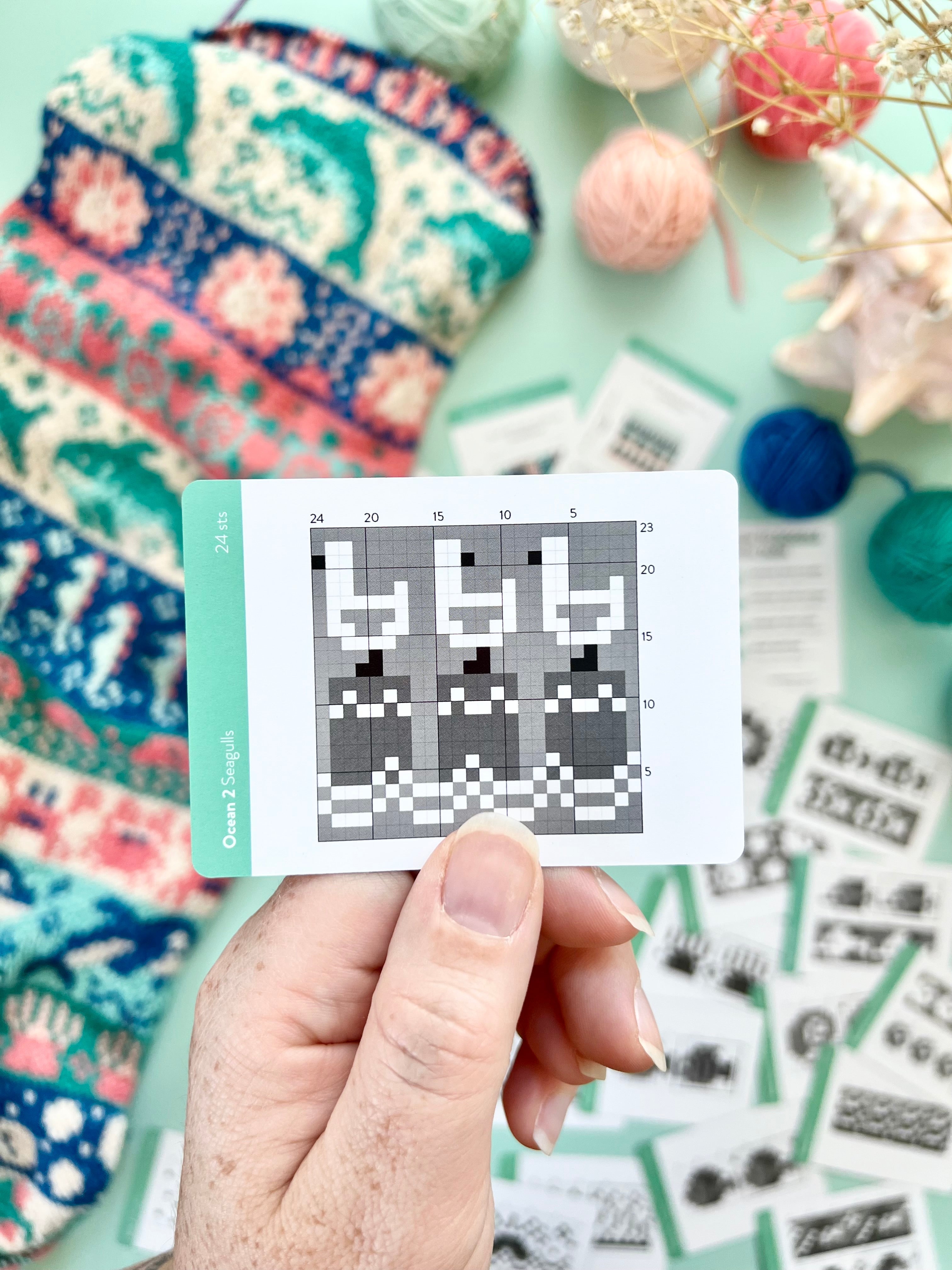 Hand holding an Ocean 2 Doodle jellyfish colorwork chart card