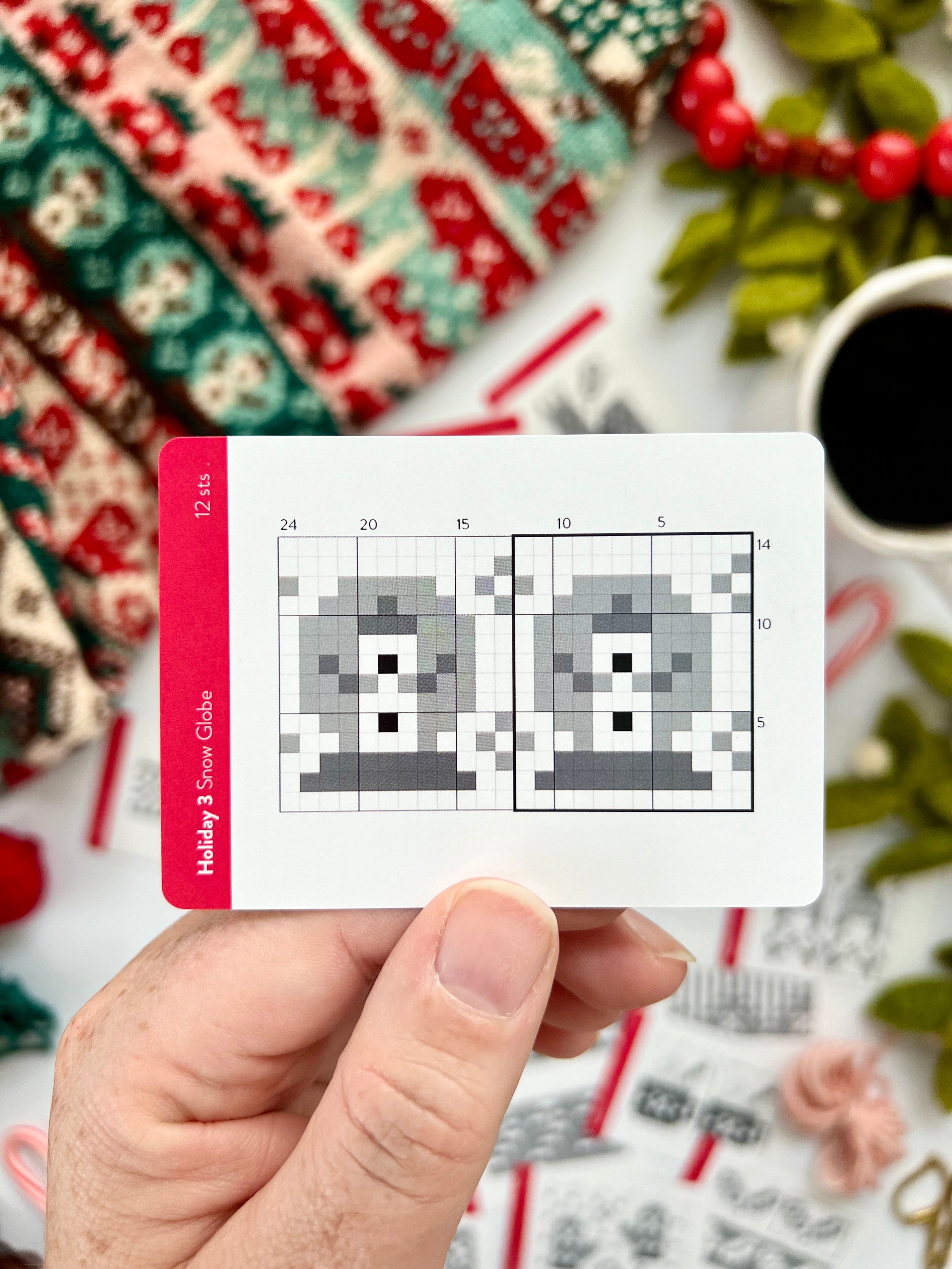 Hand holding a Holiday 3 Doodle snow globe colorwork chart card