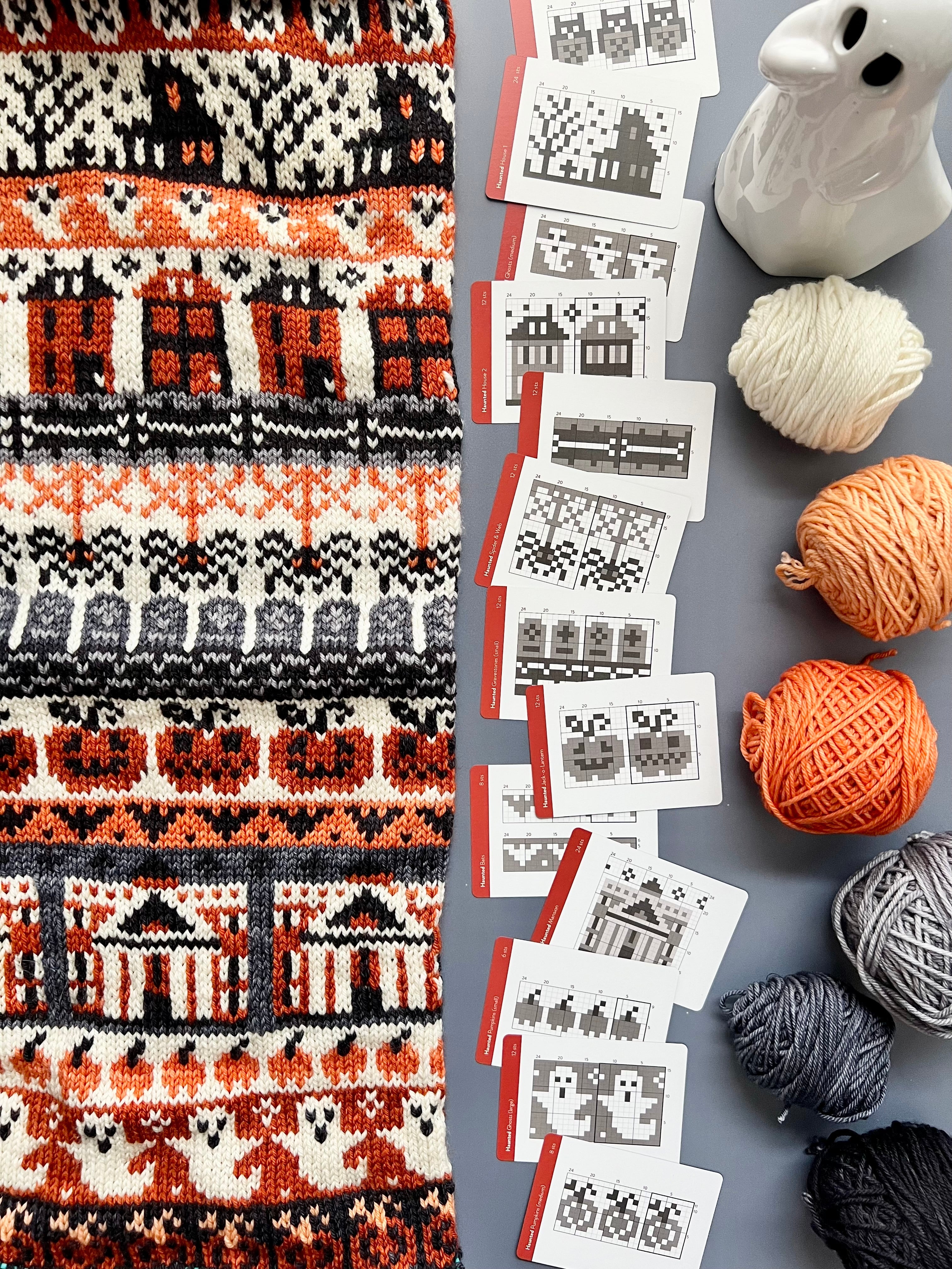 Haunted Doodle chart cards beside an orange and black haunted house colorwork knit