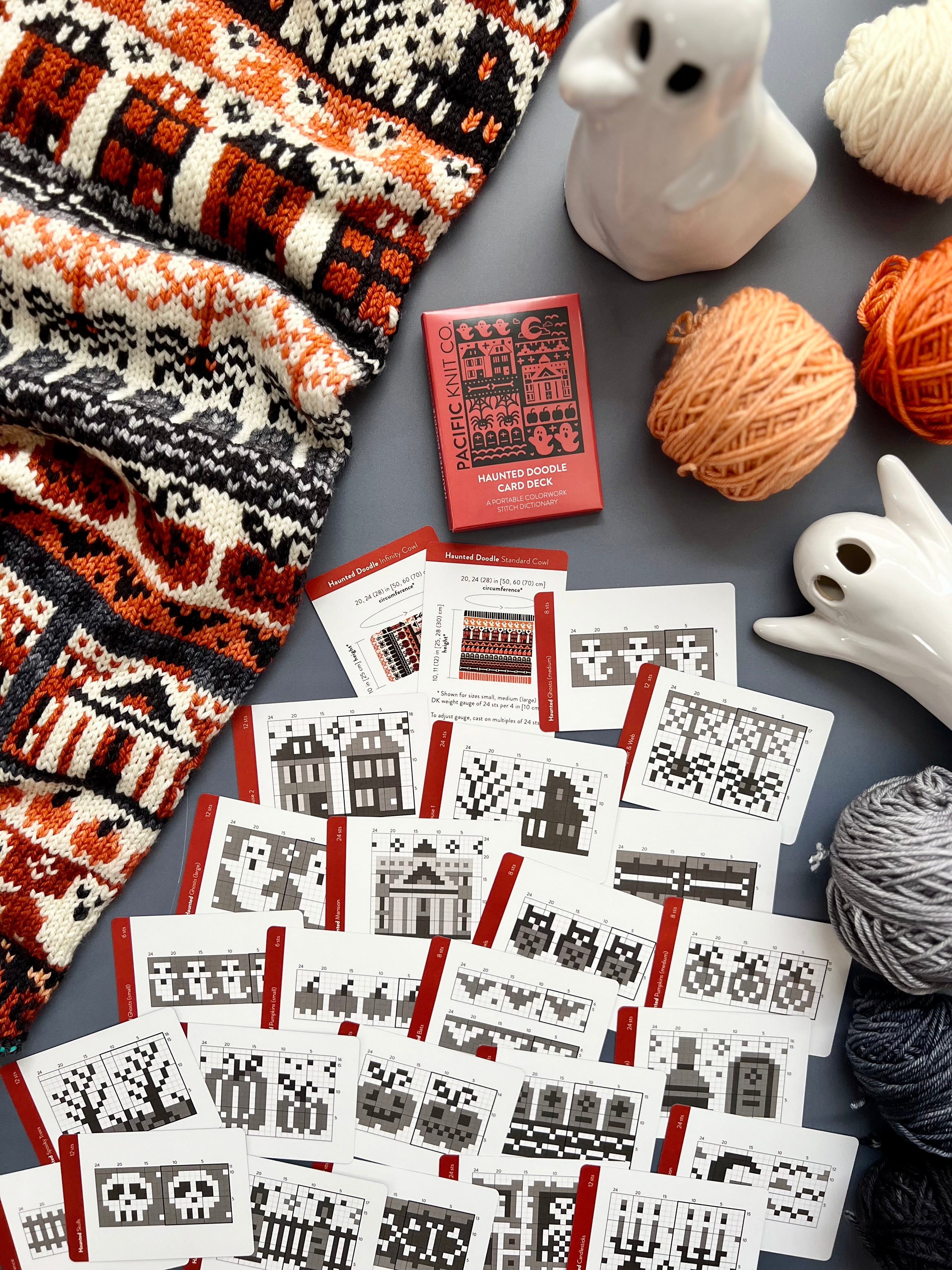 Haunted Doodle deck and chart cards scattered with ghost figurines and grey yarn