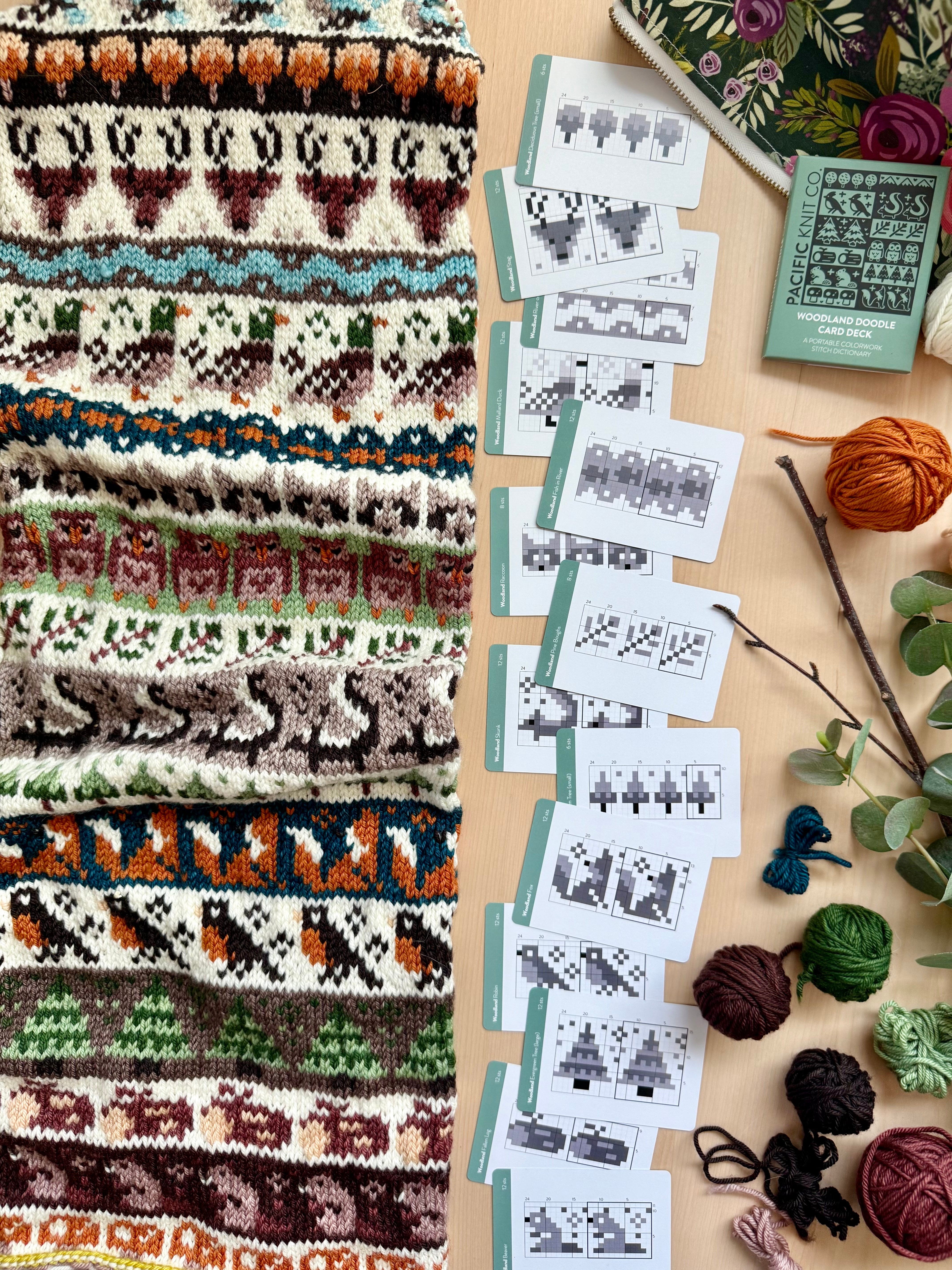 Woodland Doodle colorwork knit with fox and deer motifs beside chart cards and the deck