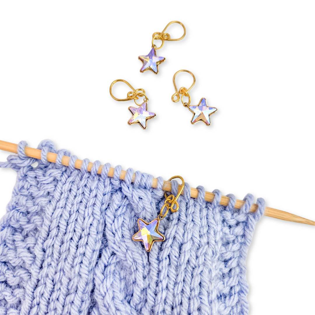 Blue garter stitch knit swatch on bamboo needles with gold snag-free stitch markers from the 2026 LYS Exclusive Winter Gift Box