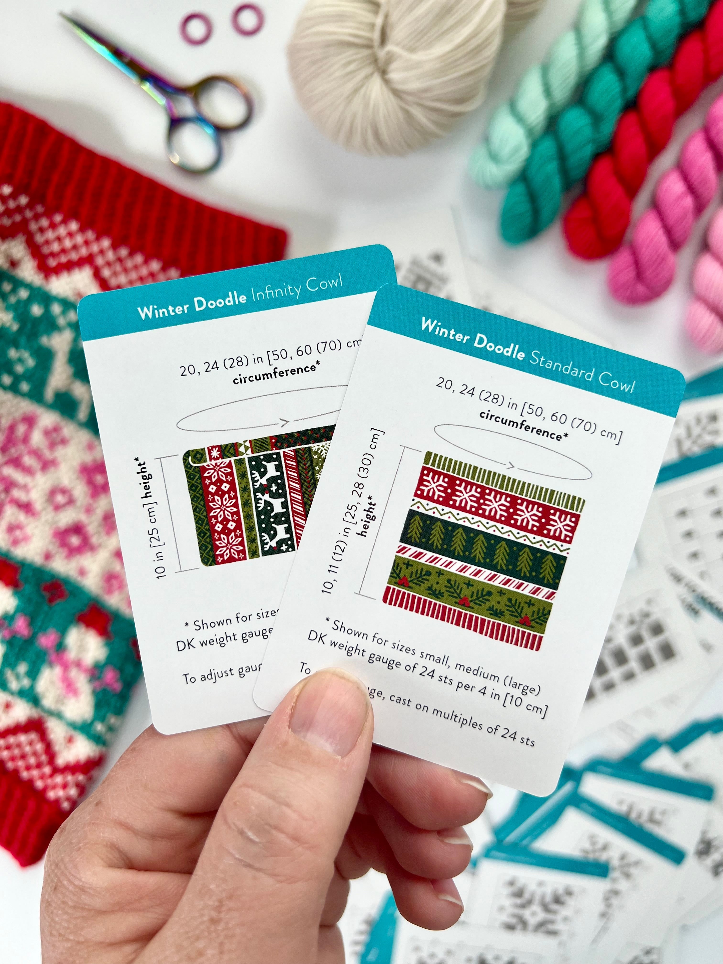Hand holding the Winter Doodle Infinity Cowl and Standard Cowl schematic cards