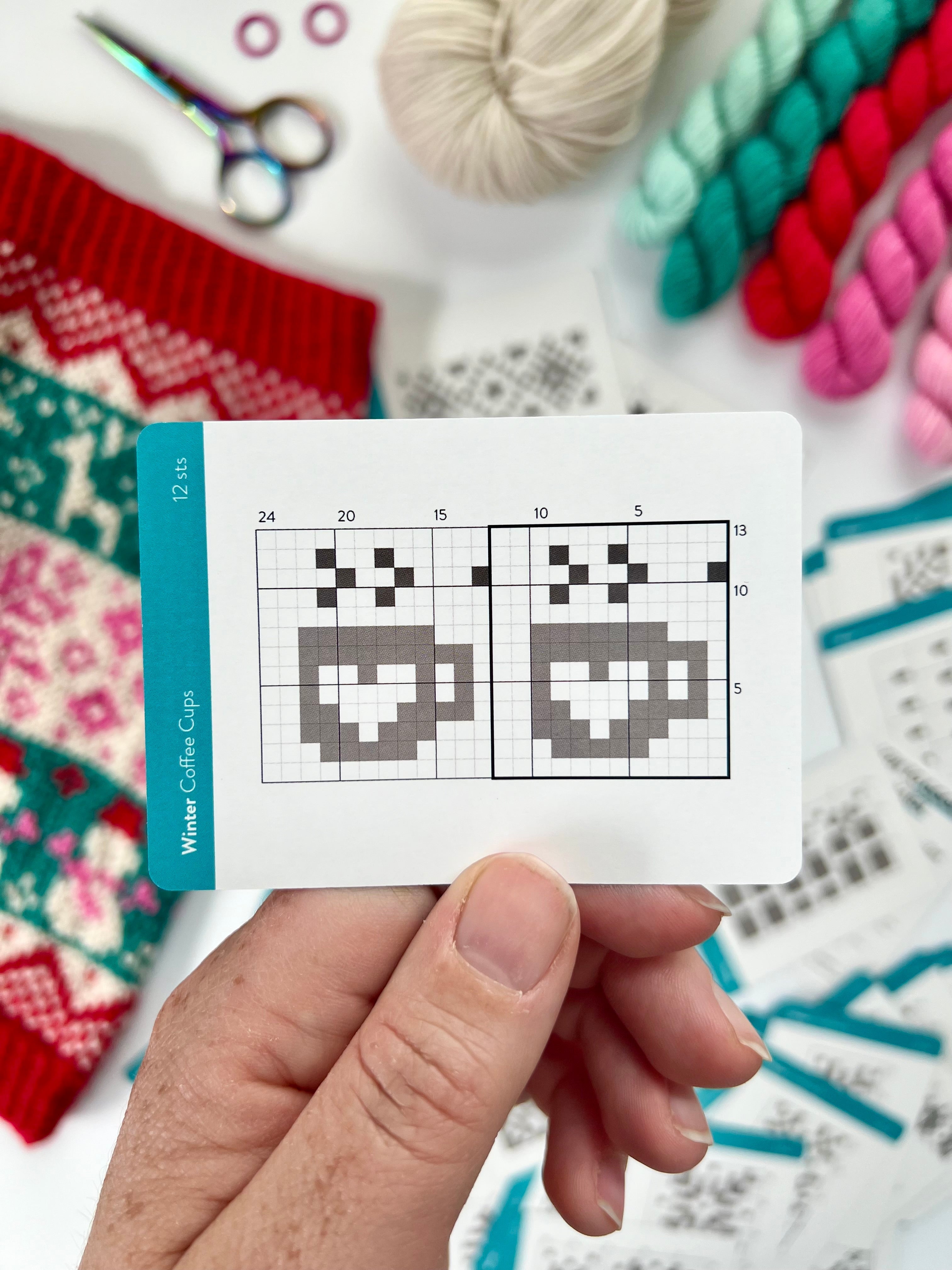 Hand holding a Winter Doodle cocoa mug colorwork chart card