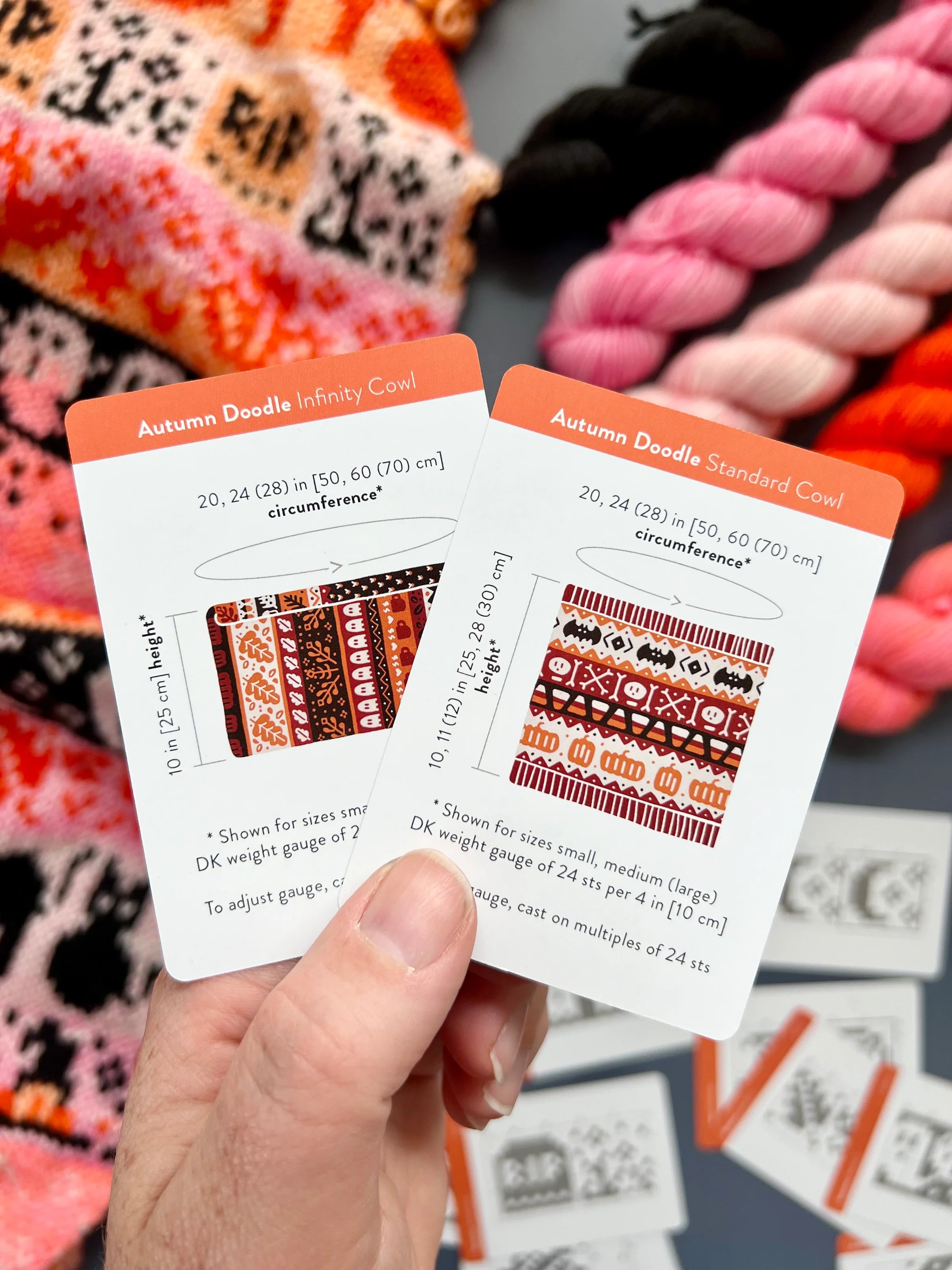 Hand holding the Autumn Doodle Infinity Cowl and Standard Cowl schematic cards