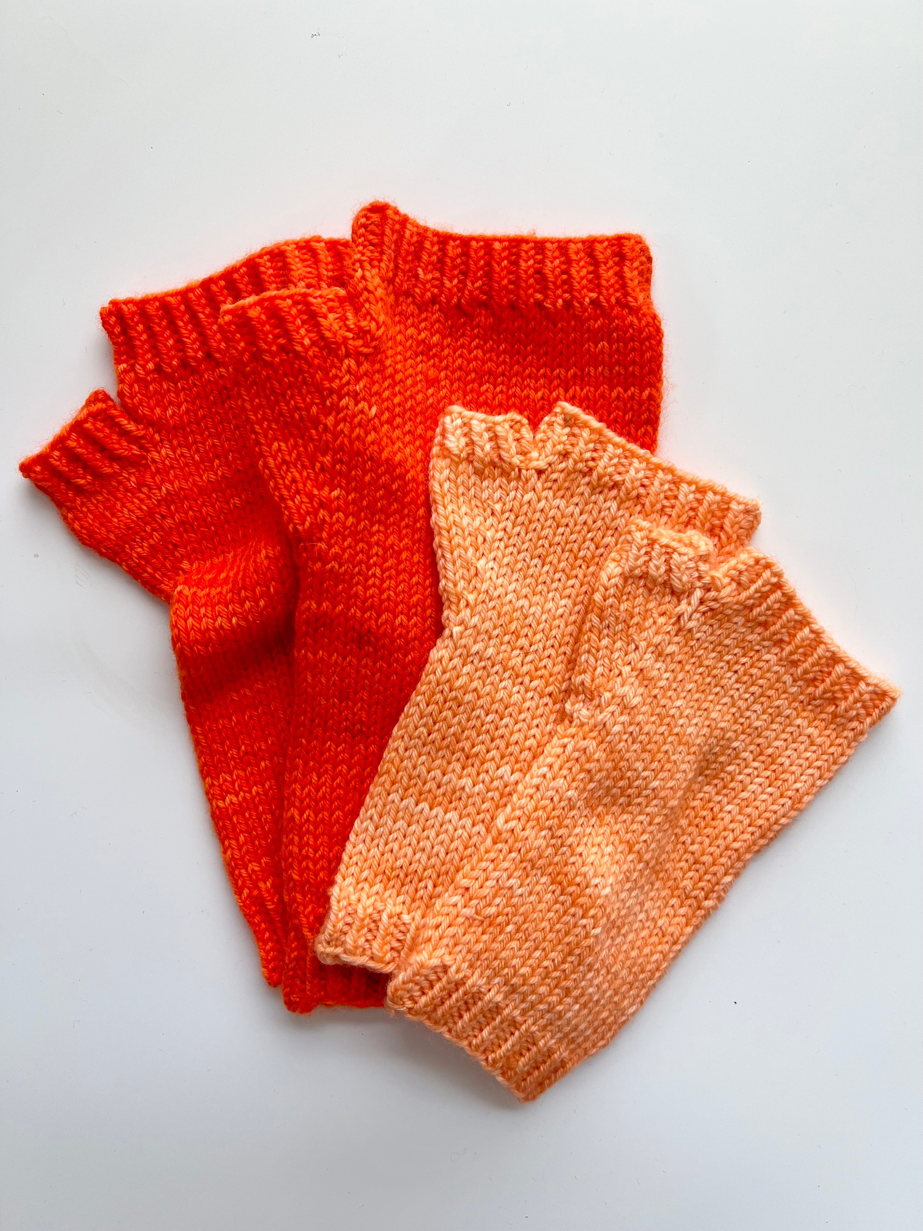 Two pairs of Base Doodle Fingerless Mitts 2 in orange and peach