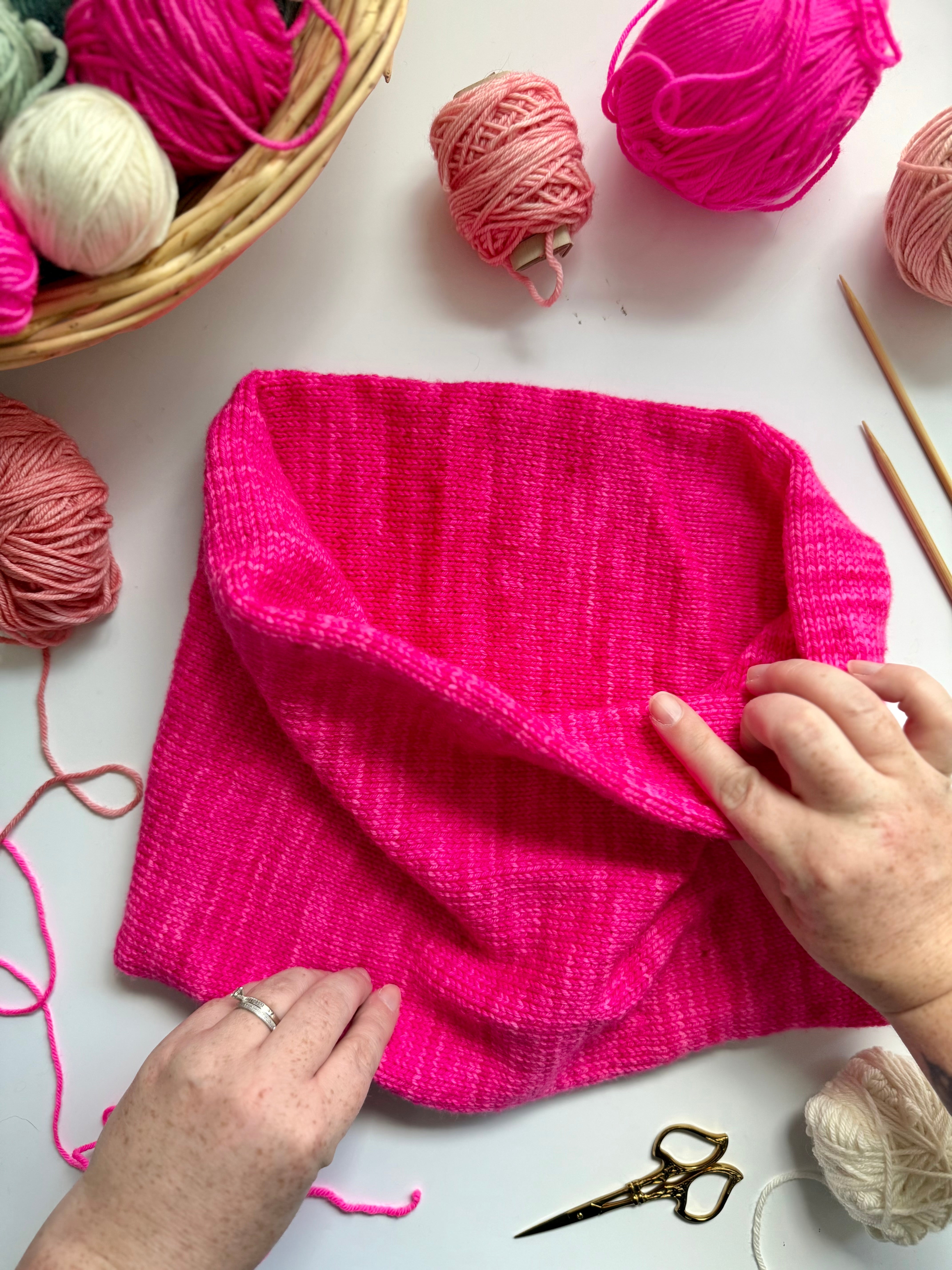 Hands adjusting a hot pink Base Doodle Infinity Cowl
