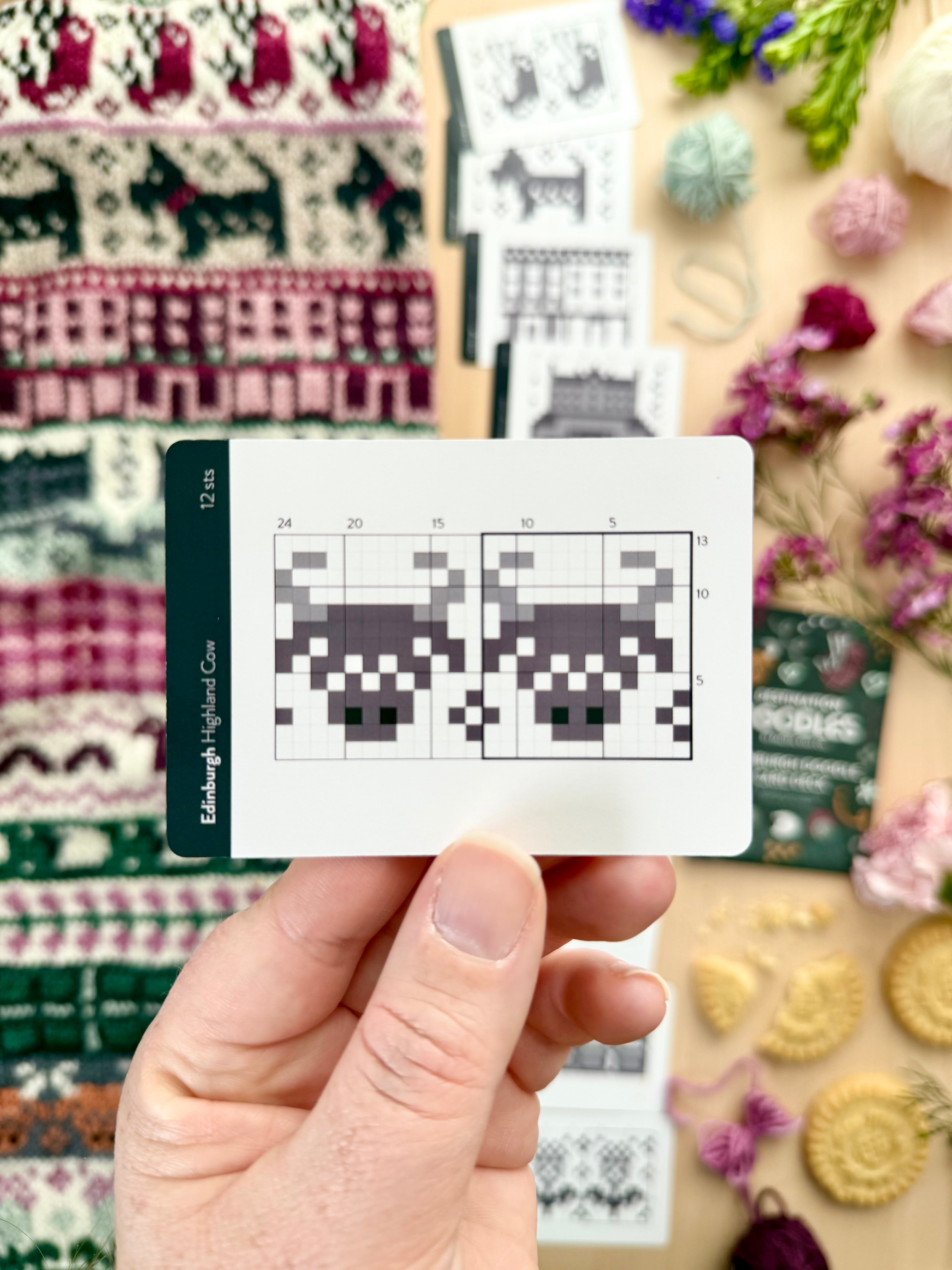 Hand holding an Edinburgh Doodle highland cow colorwork chart card