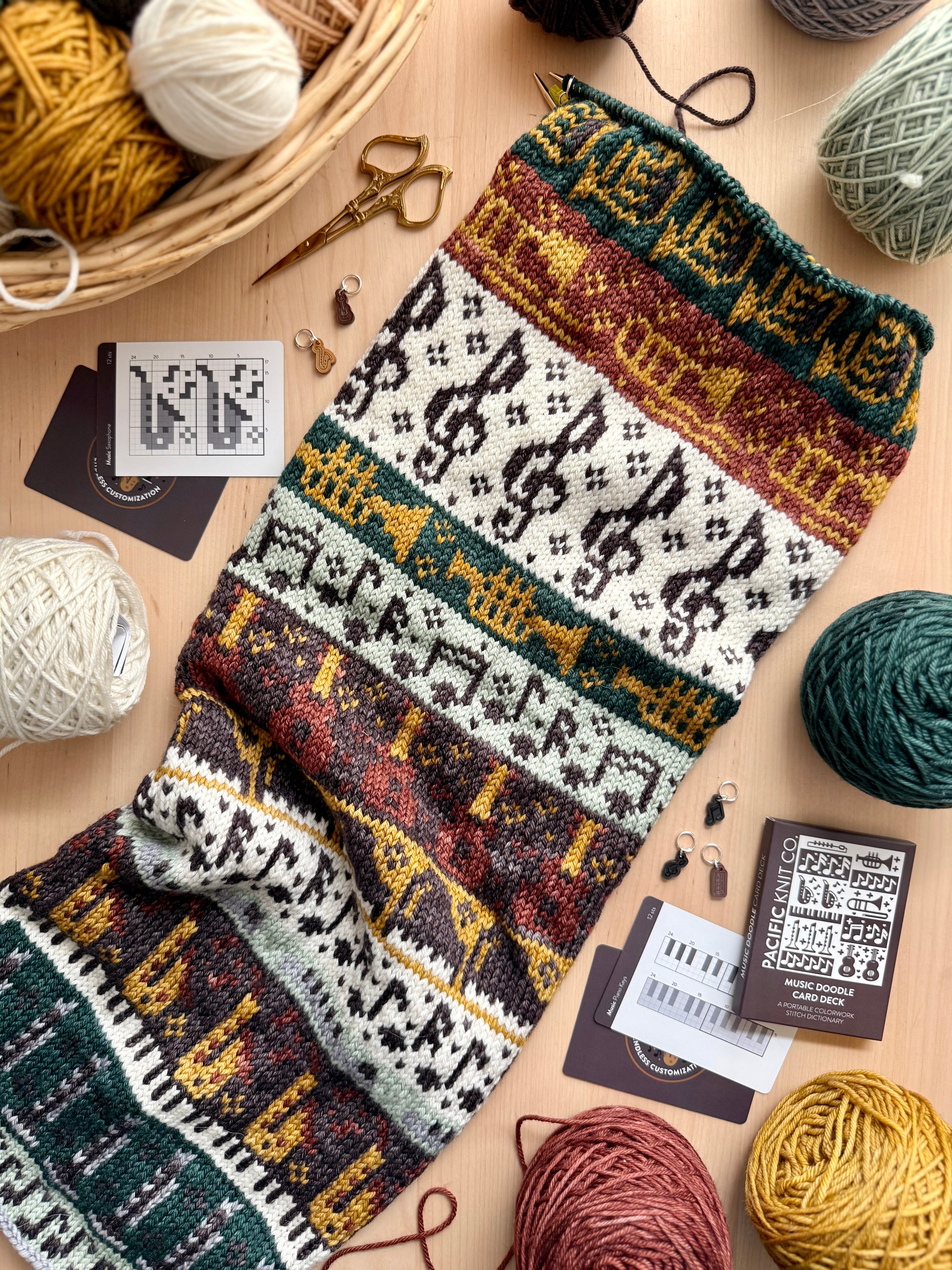 Music Doodle chart cards beside a colorwork knit with instrument motifs