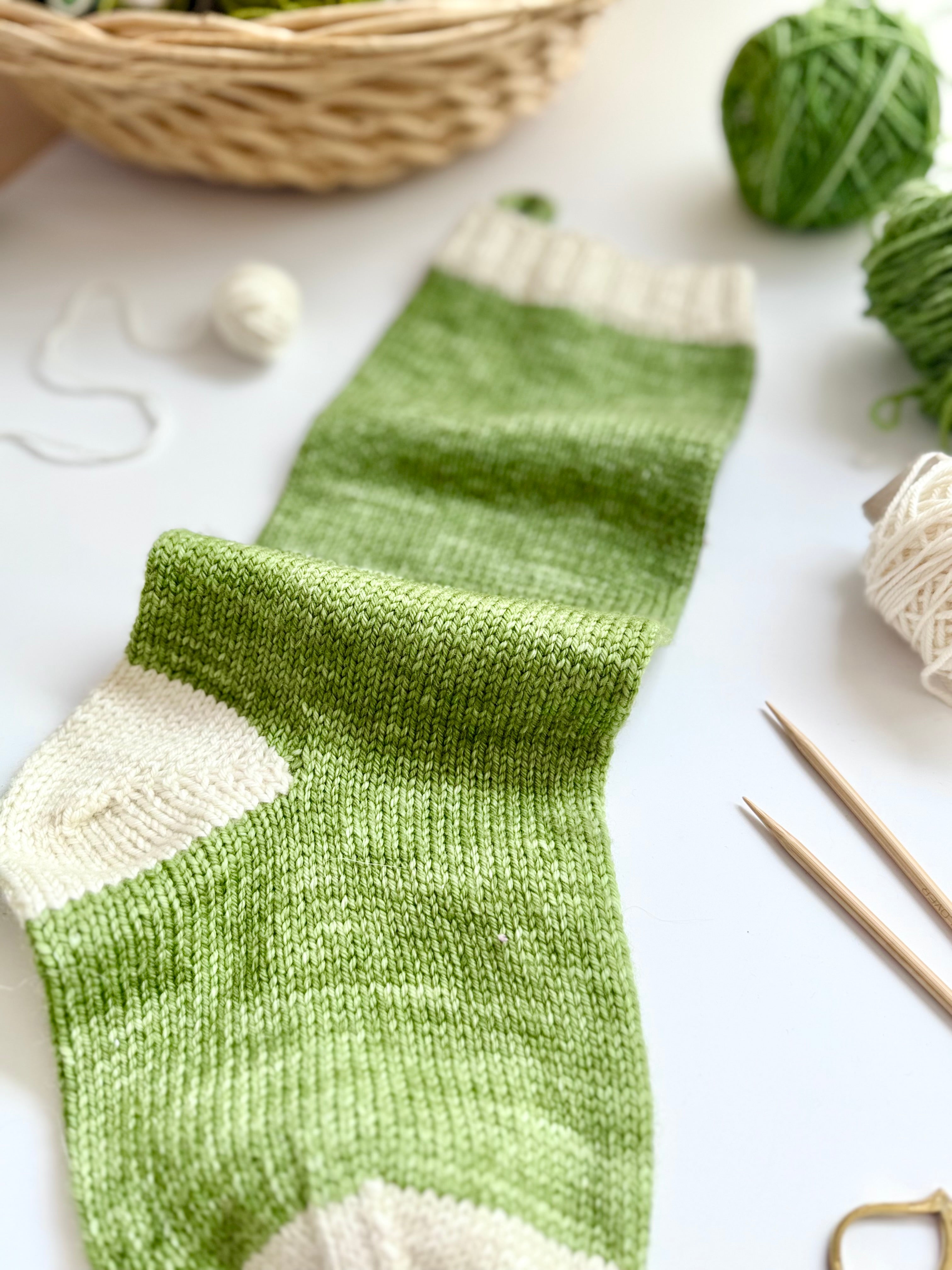 Close-up of a green and cream Base Doodle Stocking heel and toe