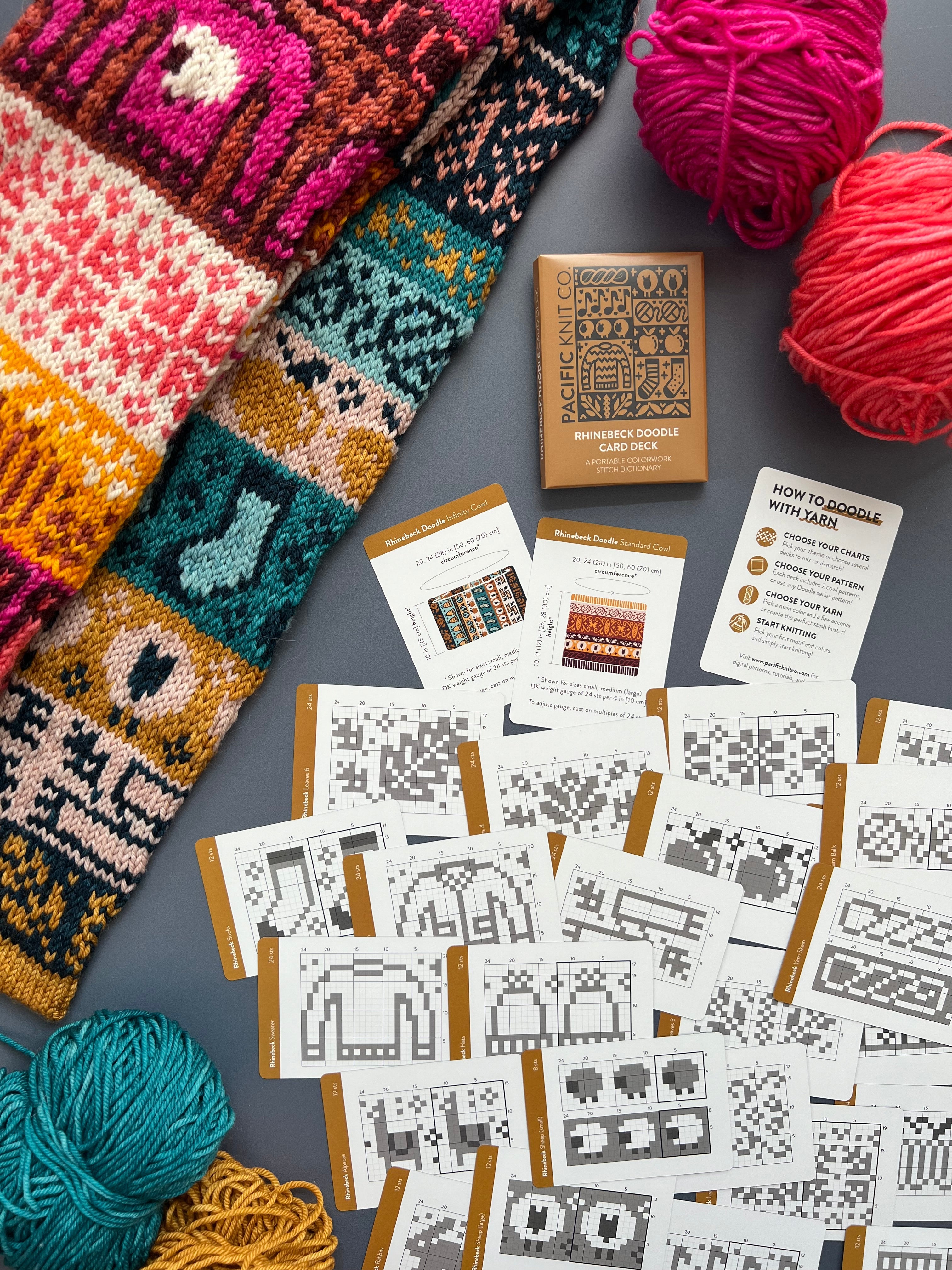 Rhinebeck Doodle deck and chart cards scattered beside a multicolor colorwork knit