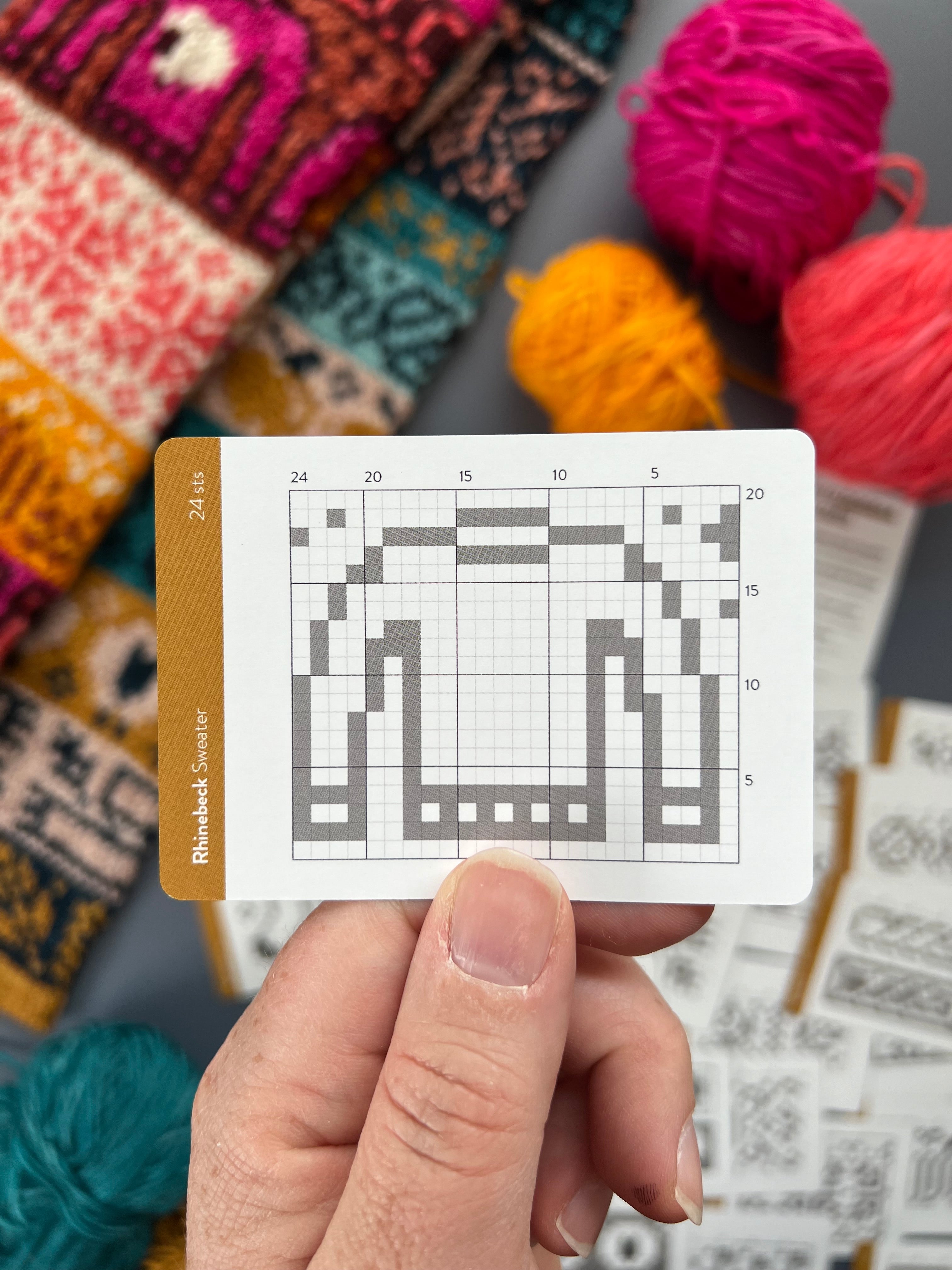 Hand holding a Rhinebeck Doodle sweater colorwork chart card