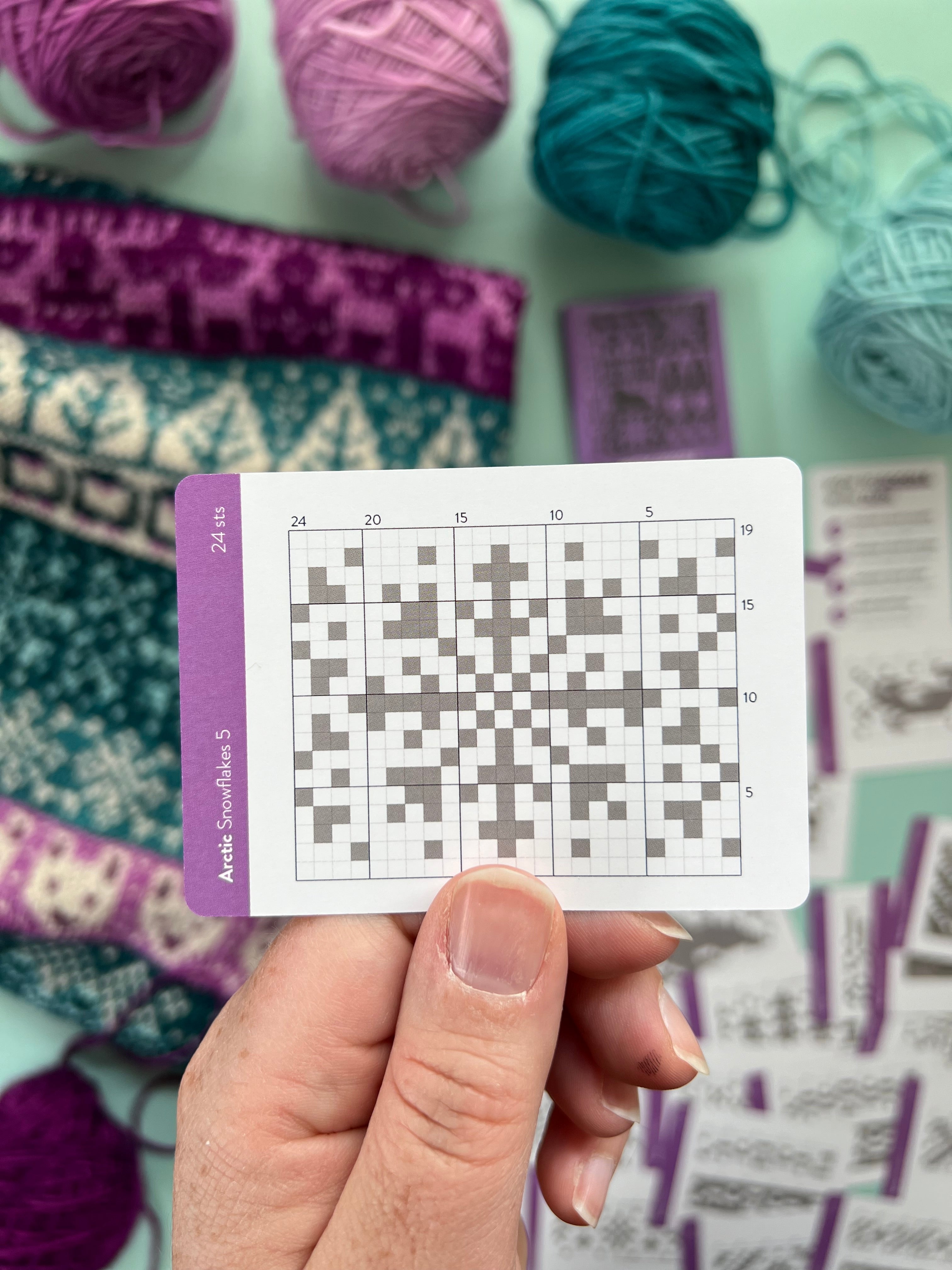 Hand holding an Arctic Doodle snowflake colorwork chart card