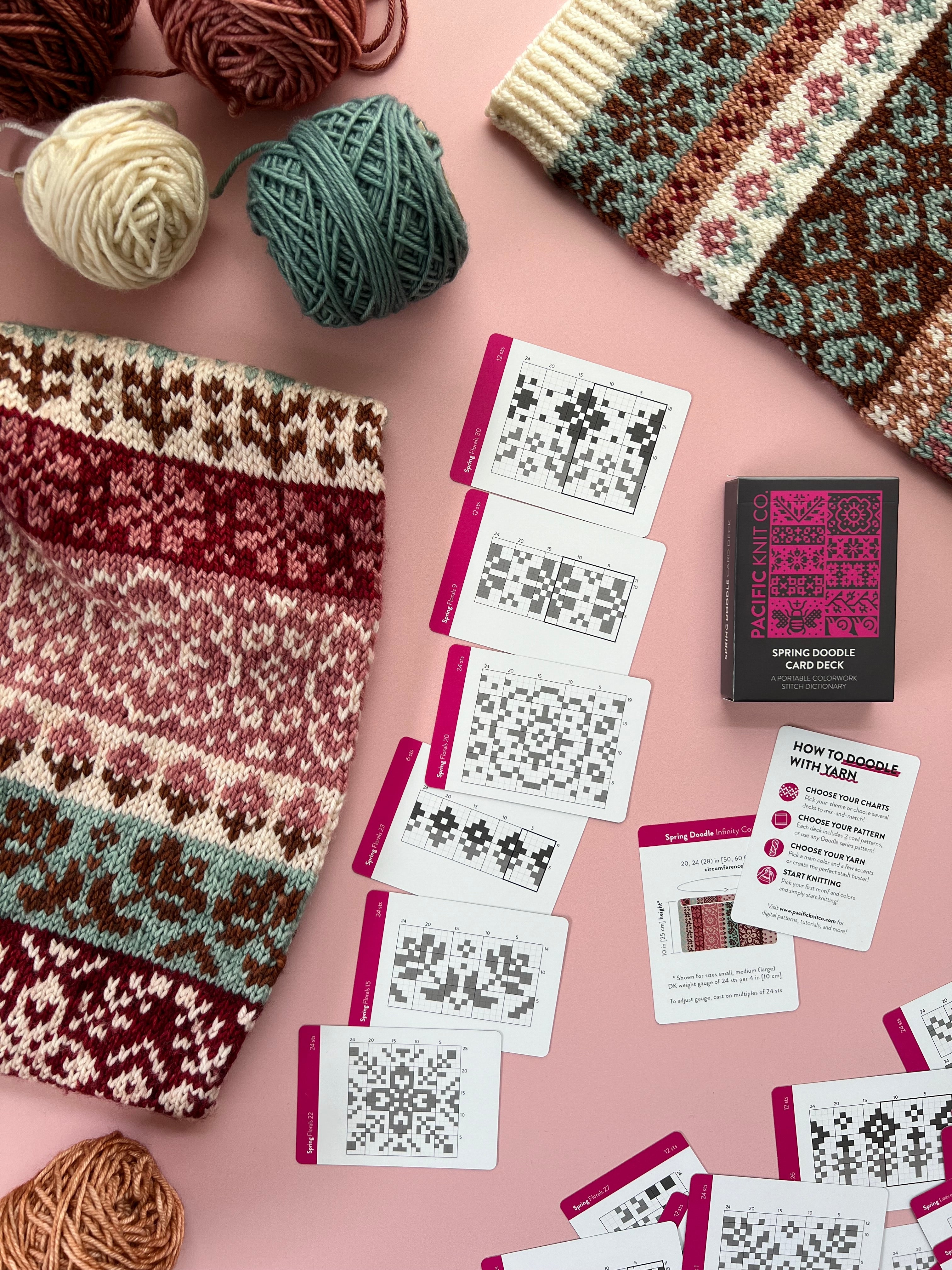 Spring Doodle floral colorwork cowl with chart cards and deck on a pink background