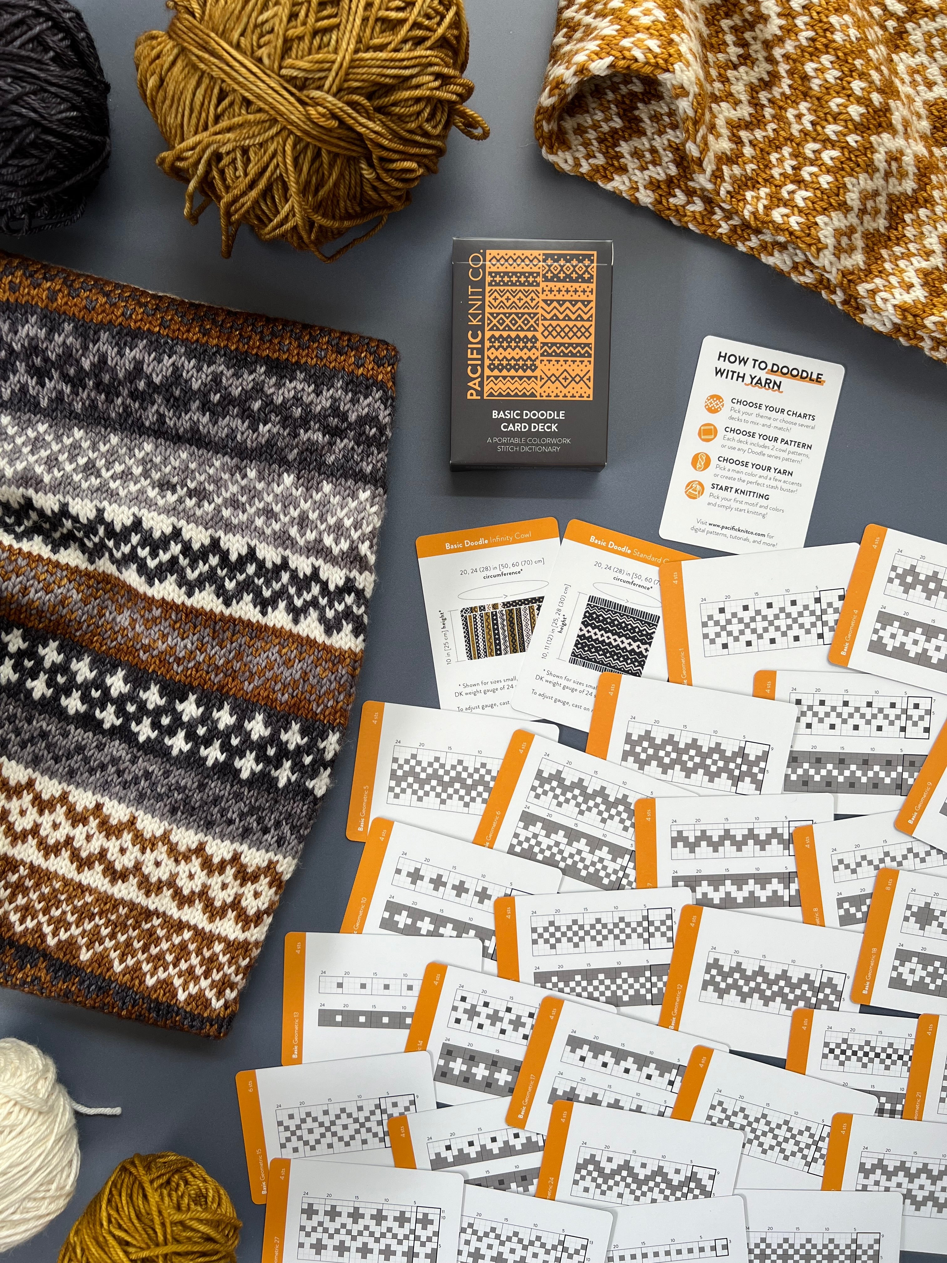 Basic Doodle chart cards spread beside a gold, brown and cream colorwork knit