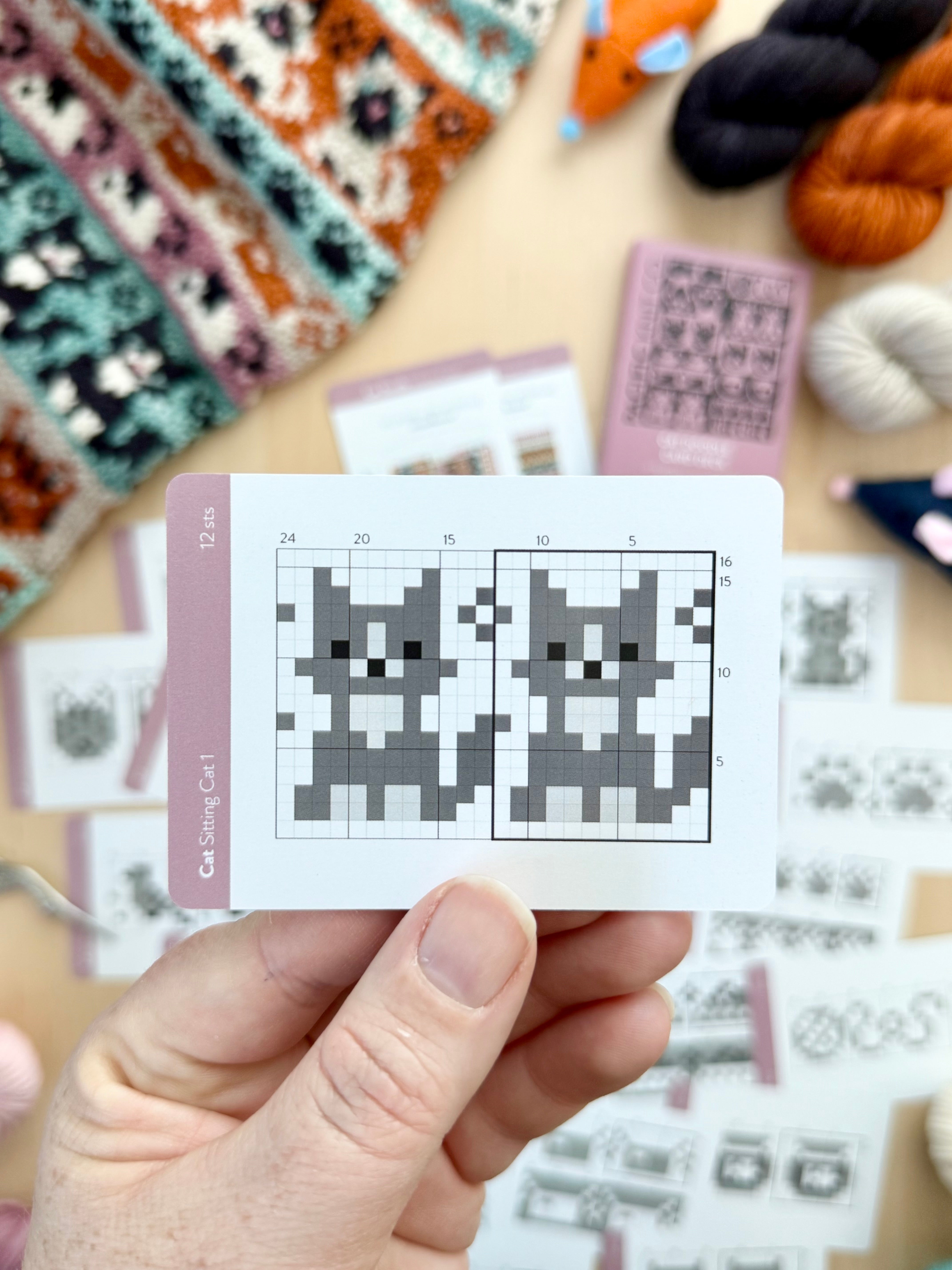 Hand holding a Cat Doodle sitting cat colorwork chart card