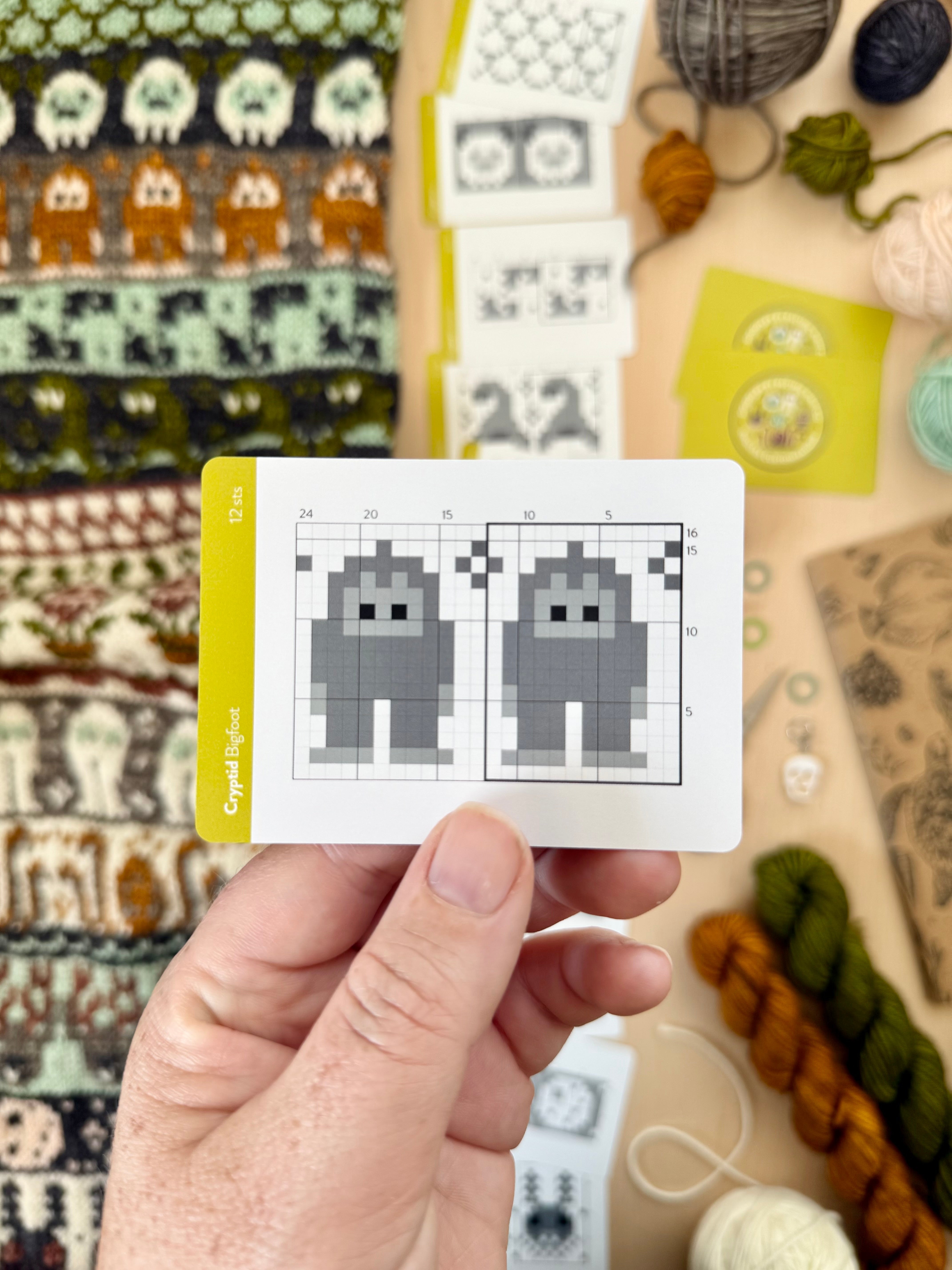 Hand holding a Cryptid Doodle Bigfoot colorwork chart card