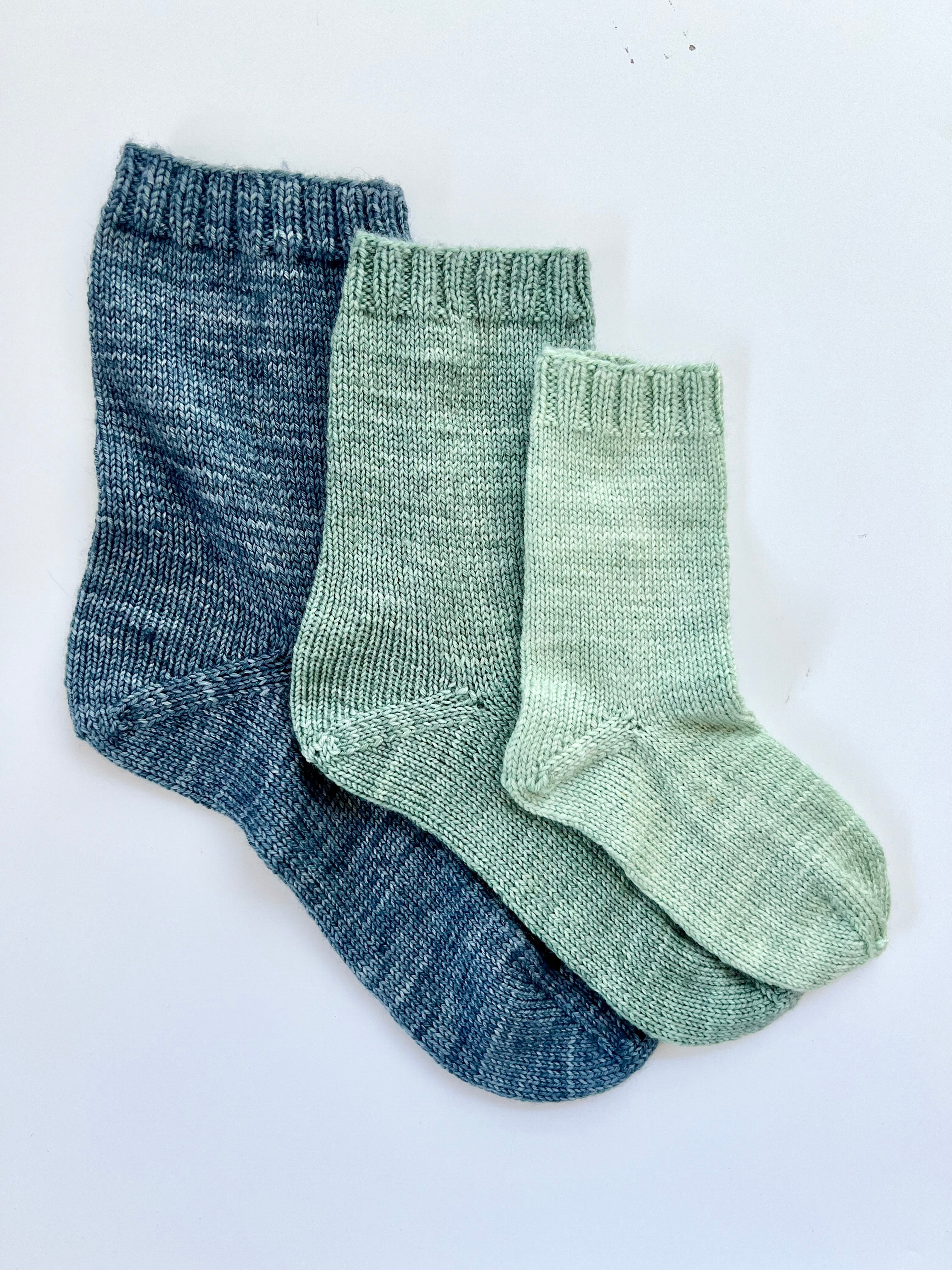 Three Base Doodle Top-Down Socks in blue and green fingering weight yarn
