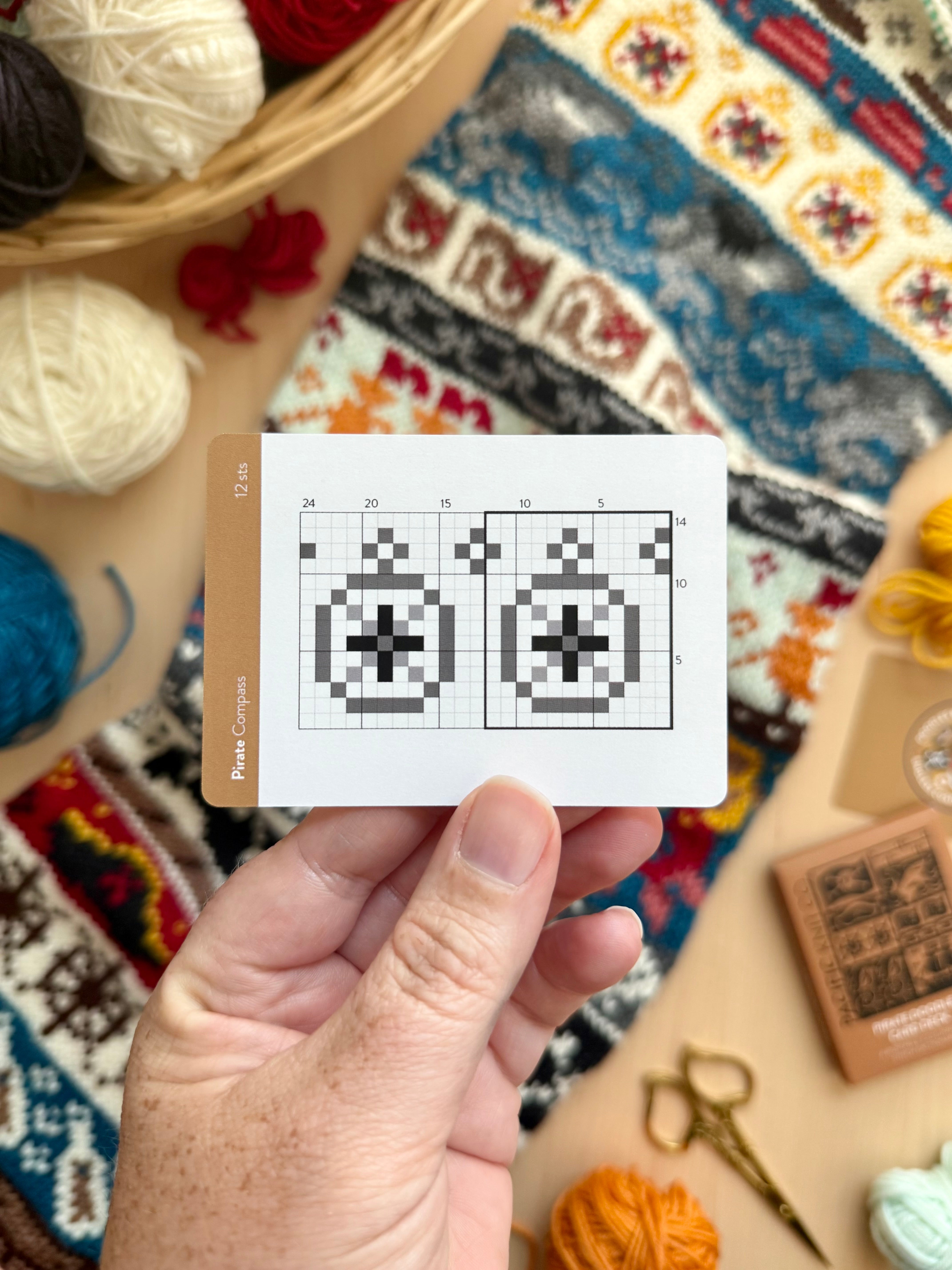 Hand holding a Pirate Doodle compass colorwork chart card