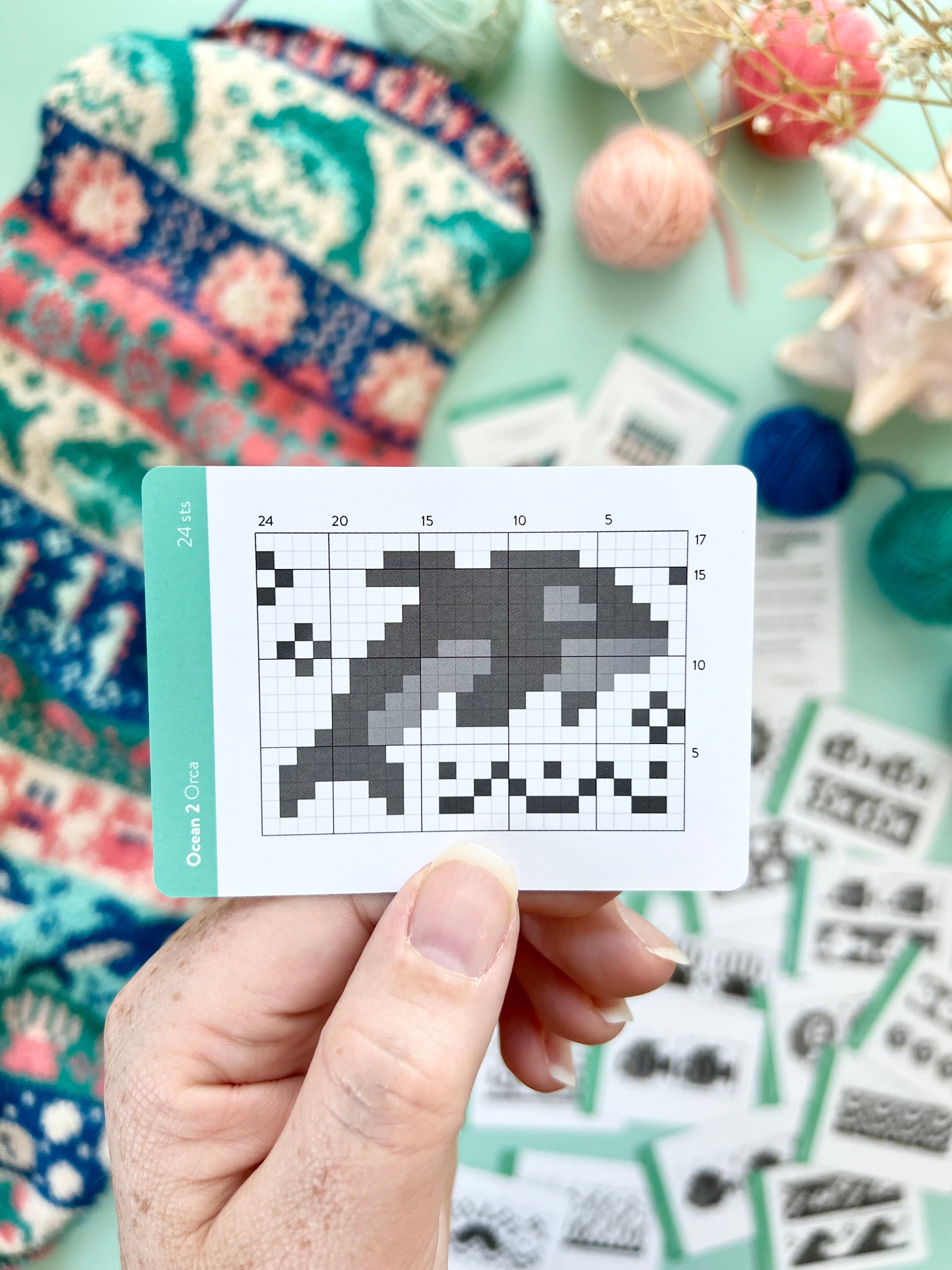 Hand holding an Ocean 2 Doodle orca colorwork chart card