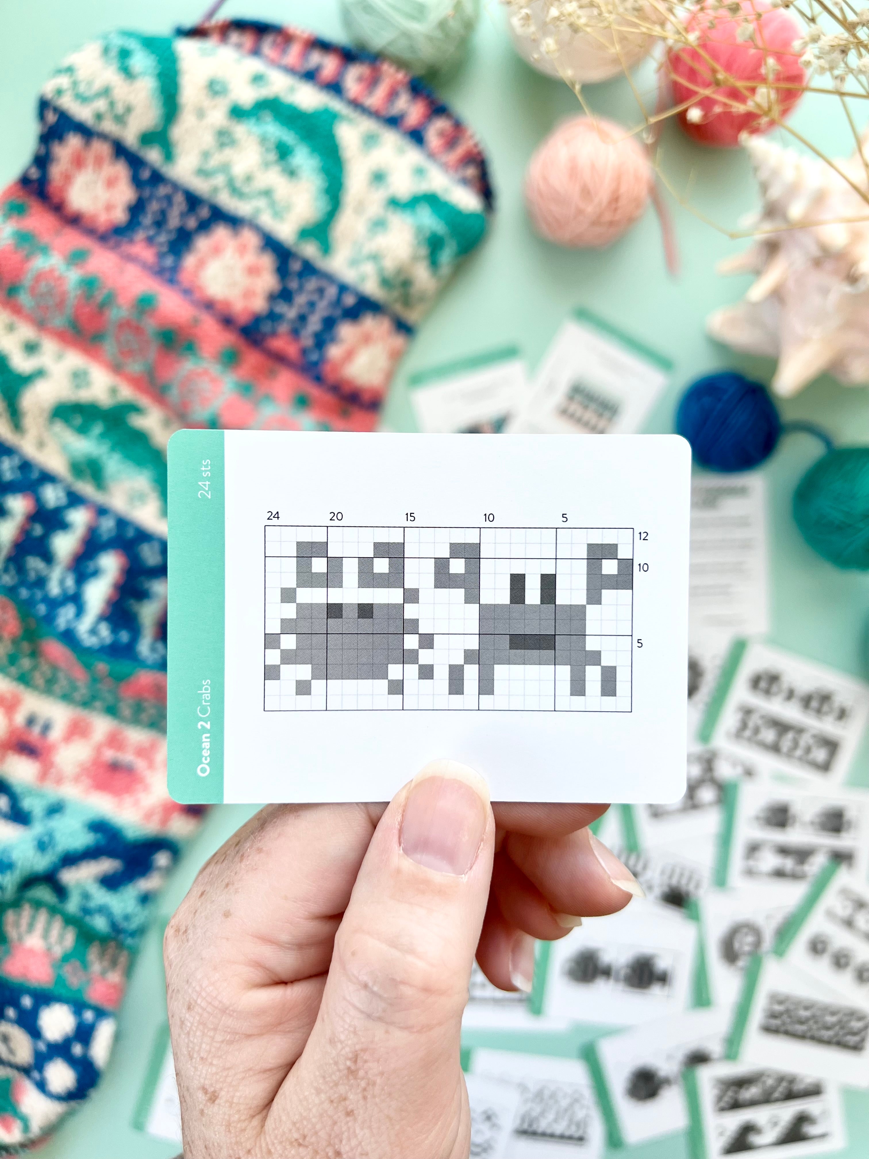 Hand holding an Ocean 2 Doodle crab colorwork chart card