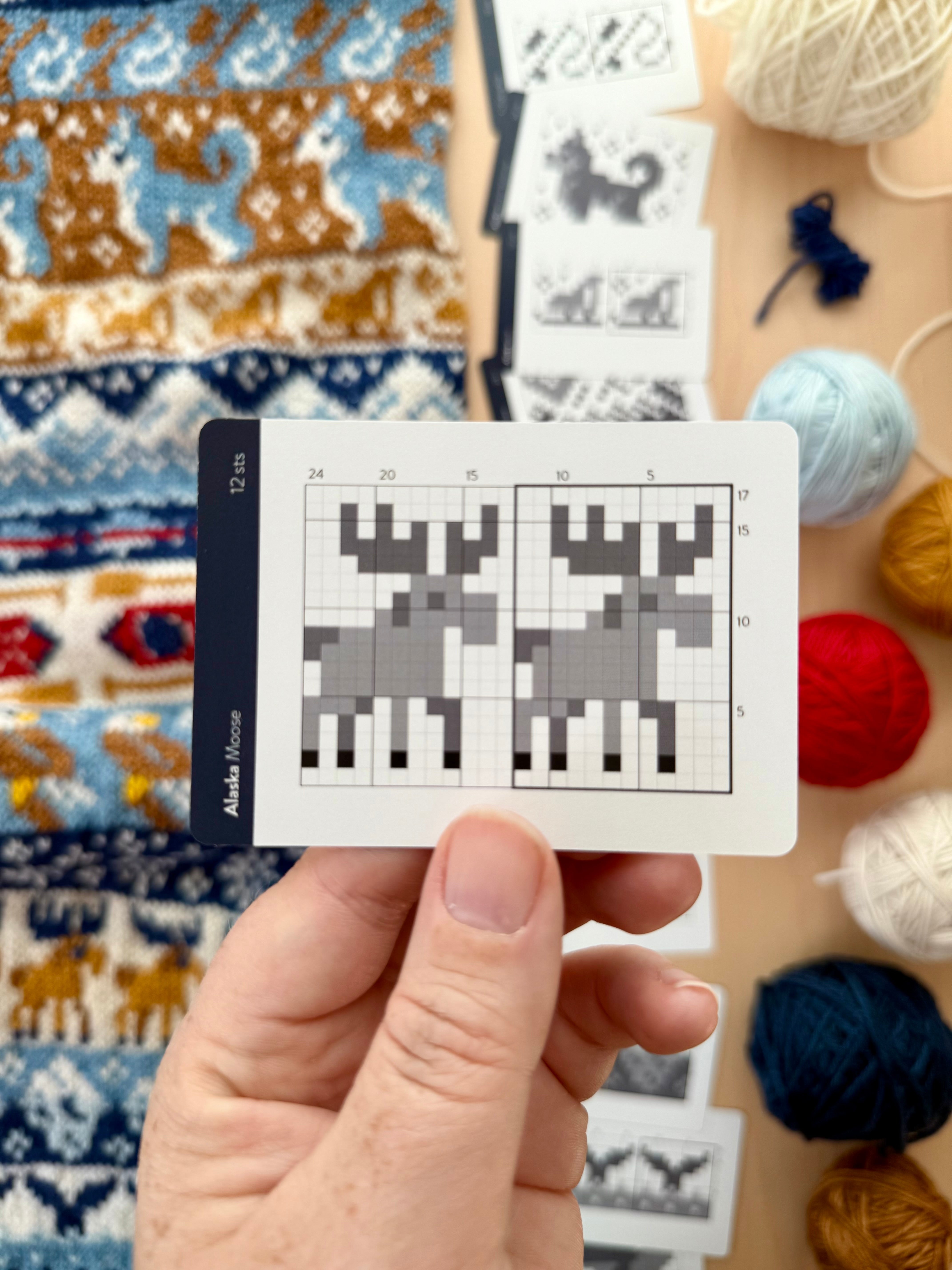 Hand holding an Alaska Doodle moose colorwork chart card