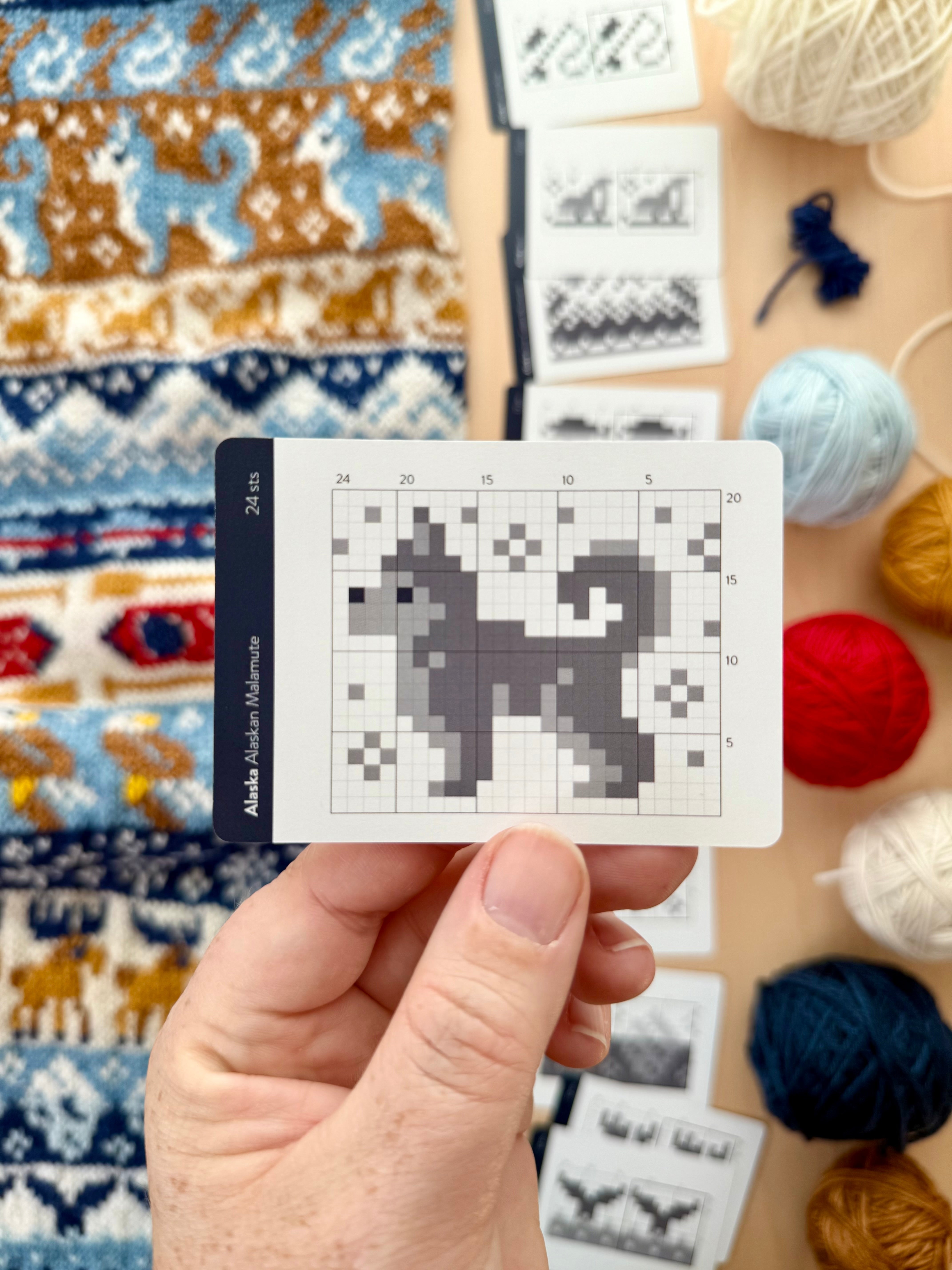 Hand holding an Alaska Doodle Alaskan malamute colorwork chart card