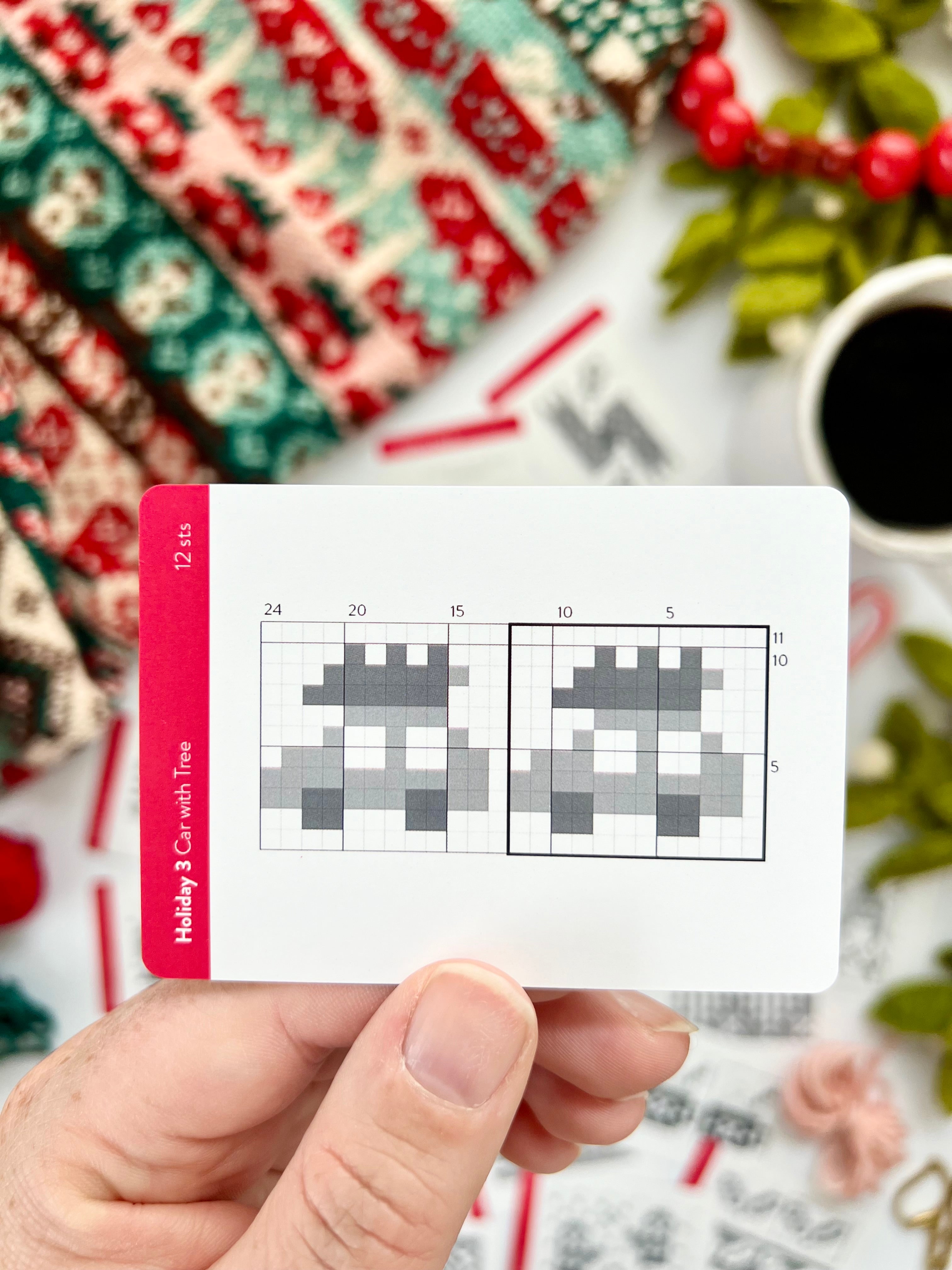 Hand holding a Holiday 3 Doodle car with tree colorwork chart card