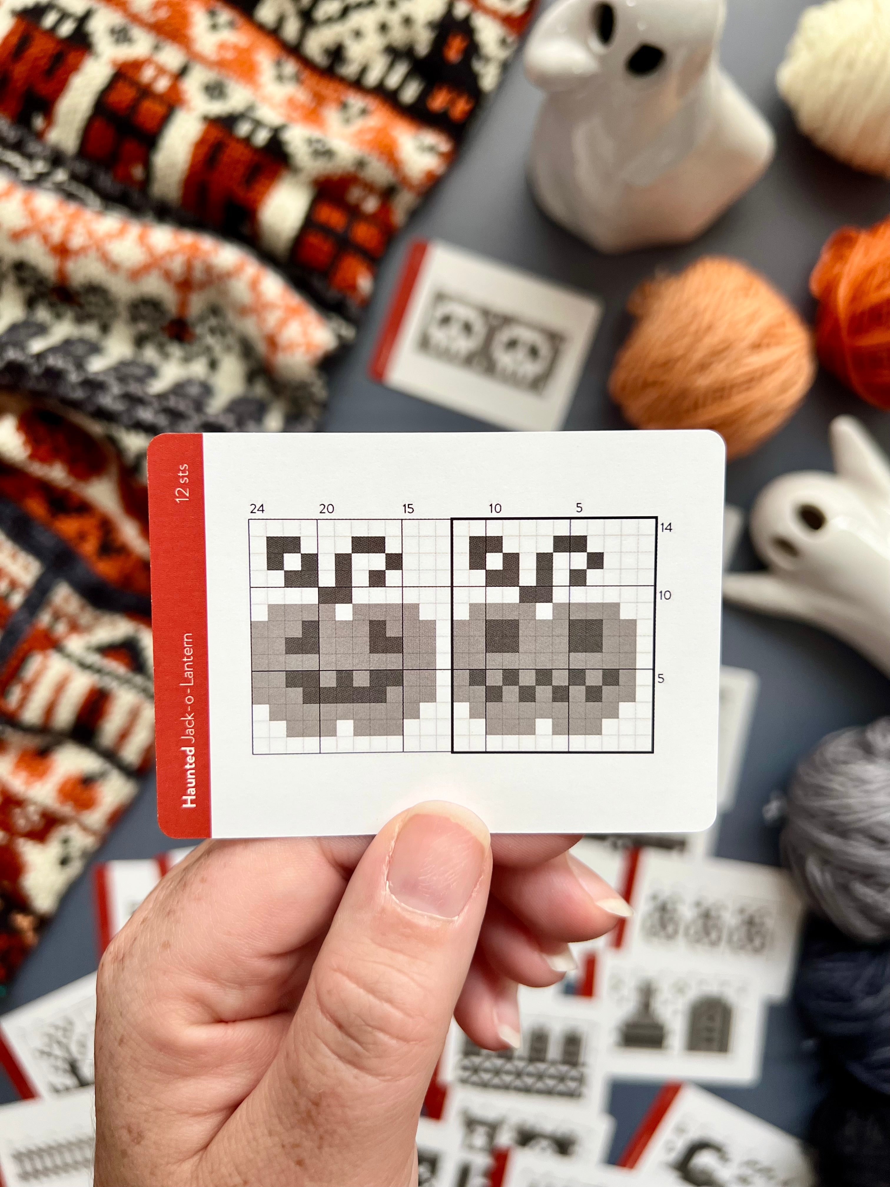 Hand holding a Haunted Doodle jack-o'-lantern colorwork chart card