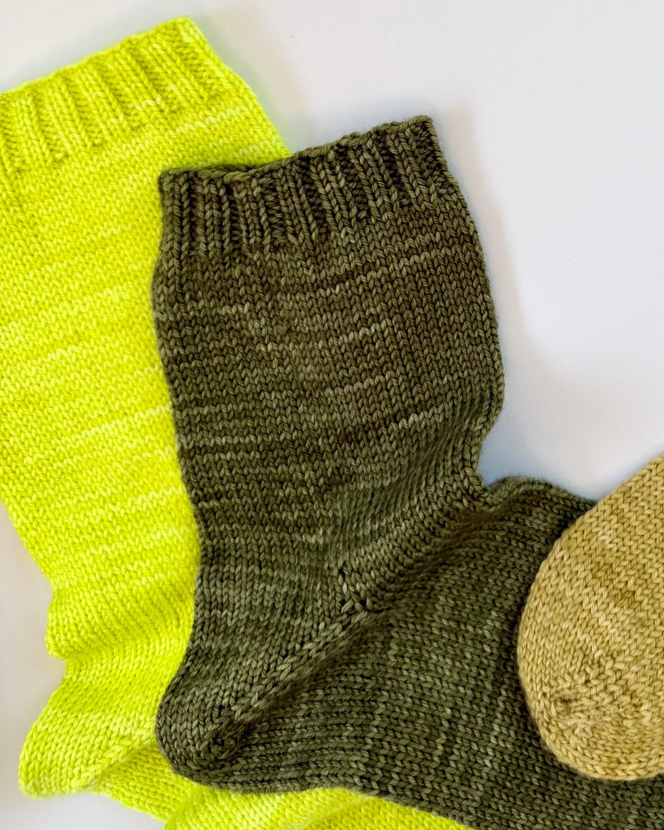 Close-up of olive and gold Base Doodle Toe-Up Socks