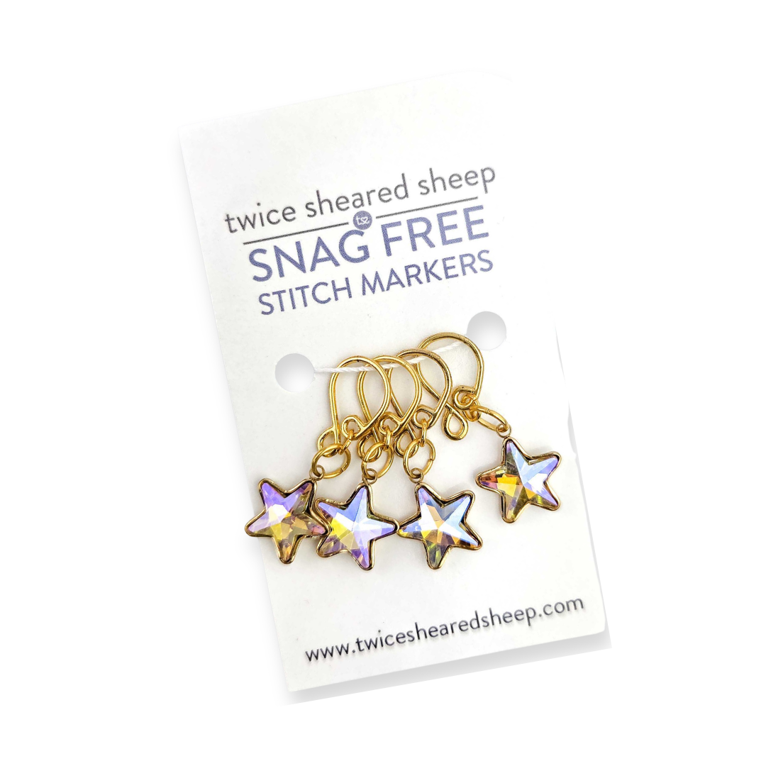 Twice Sheared Sheep Snag Free Stitch Markers tin open showing gold-tone stitch markers inside with branded label on the lid